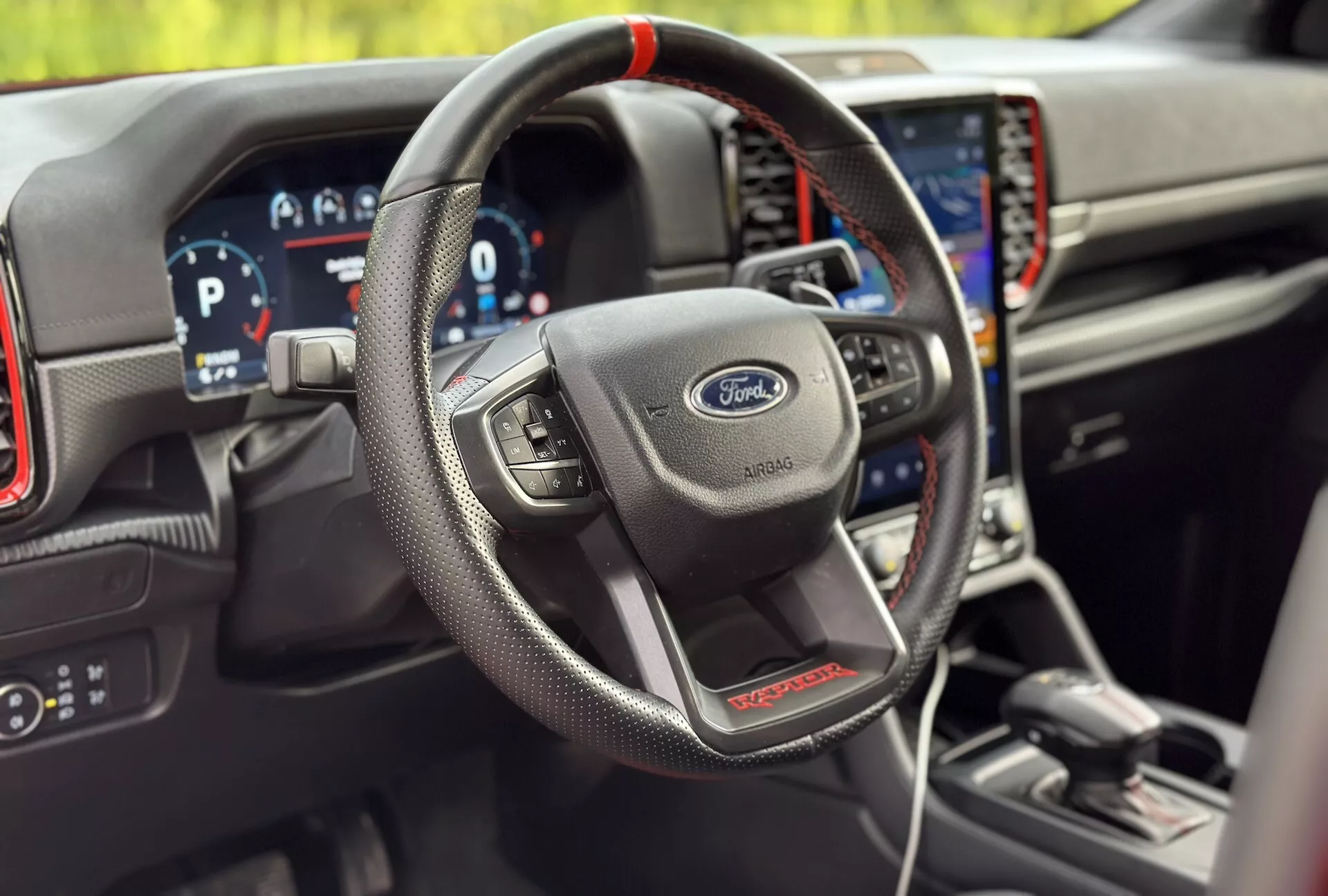 Intérieur du Ford Ranger 2022, mettant en évidence le volant gainé de cuir avec commandes multifonctions, tableau de bord numérique et système de navigation intégré dans la variante sportive ST
