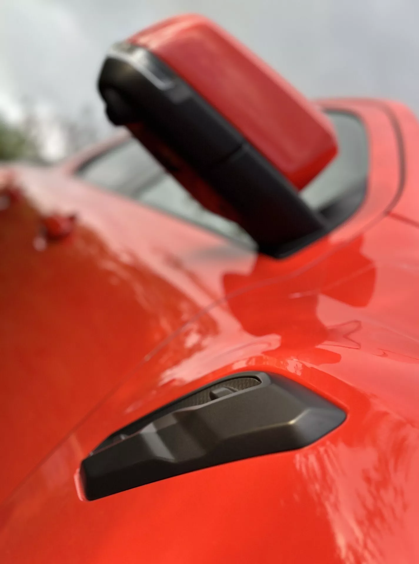 Gros plan sur l'aile arrière et le spoiler du Ford Ranger 2022 avec une finition rouge éclatante, comportant une grille noire pour une meilleure aérodynamique, mettant en évidence son design sportif sous une faible profondeur de champ