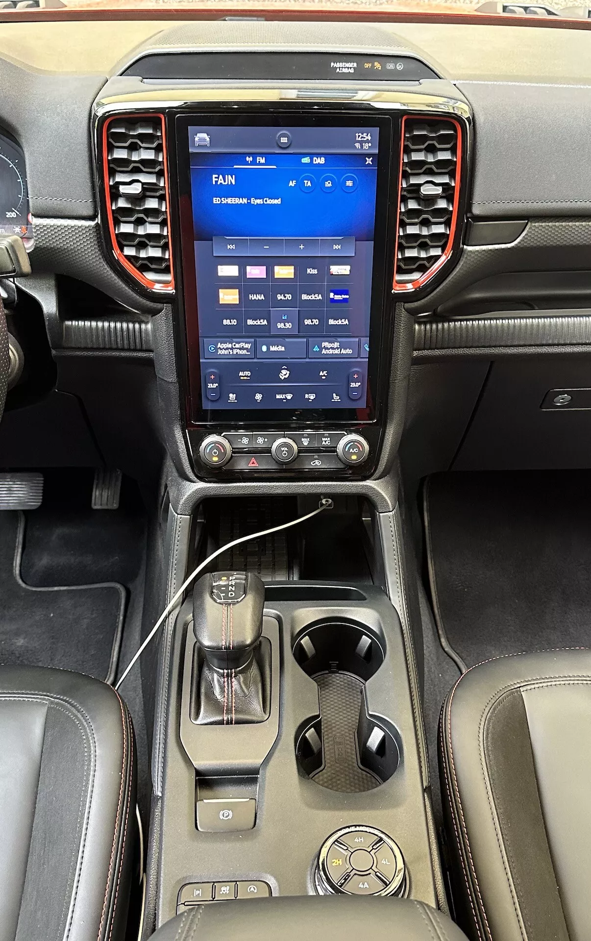 Console centrale sophistiquée du Ford Ranger 2022 dotée d'un grand système d'infodivertissement tactile vertical, de boutons de contrôle climatique, du levier de vitesse et de finitions en cuir de luxe