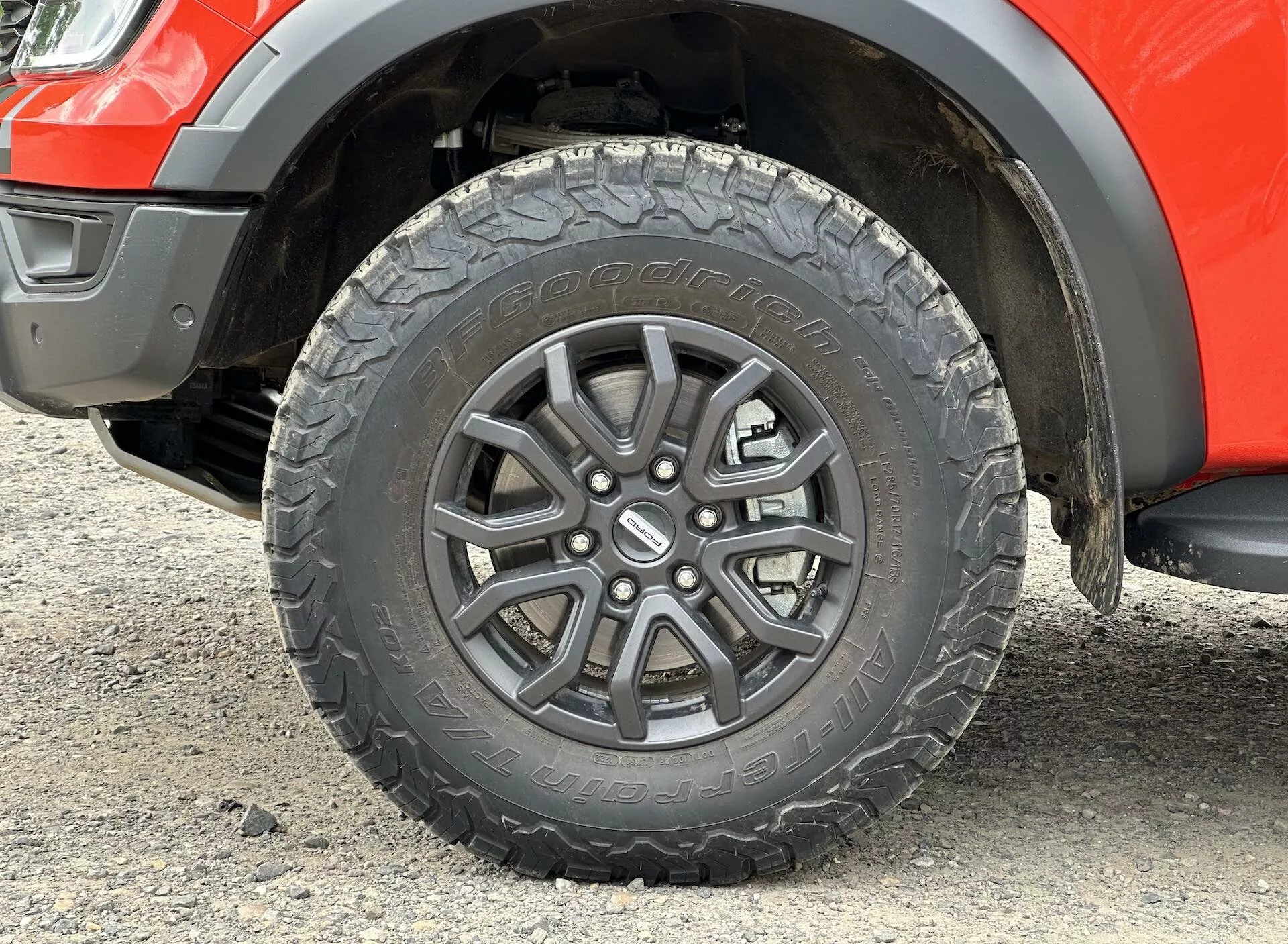 Gros plan sur la roue du Ford Ranger 2022, présentant un design alliage à multiples rayons, une empreinte de pneu tout-terrain et un segment de l'aile avec garde au sol de la suspension visible