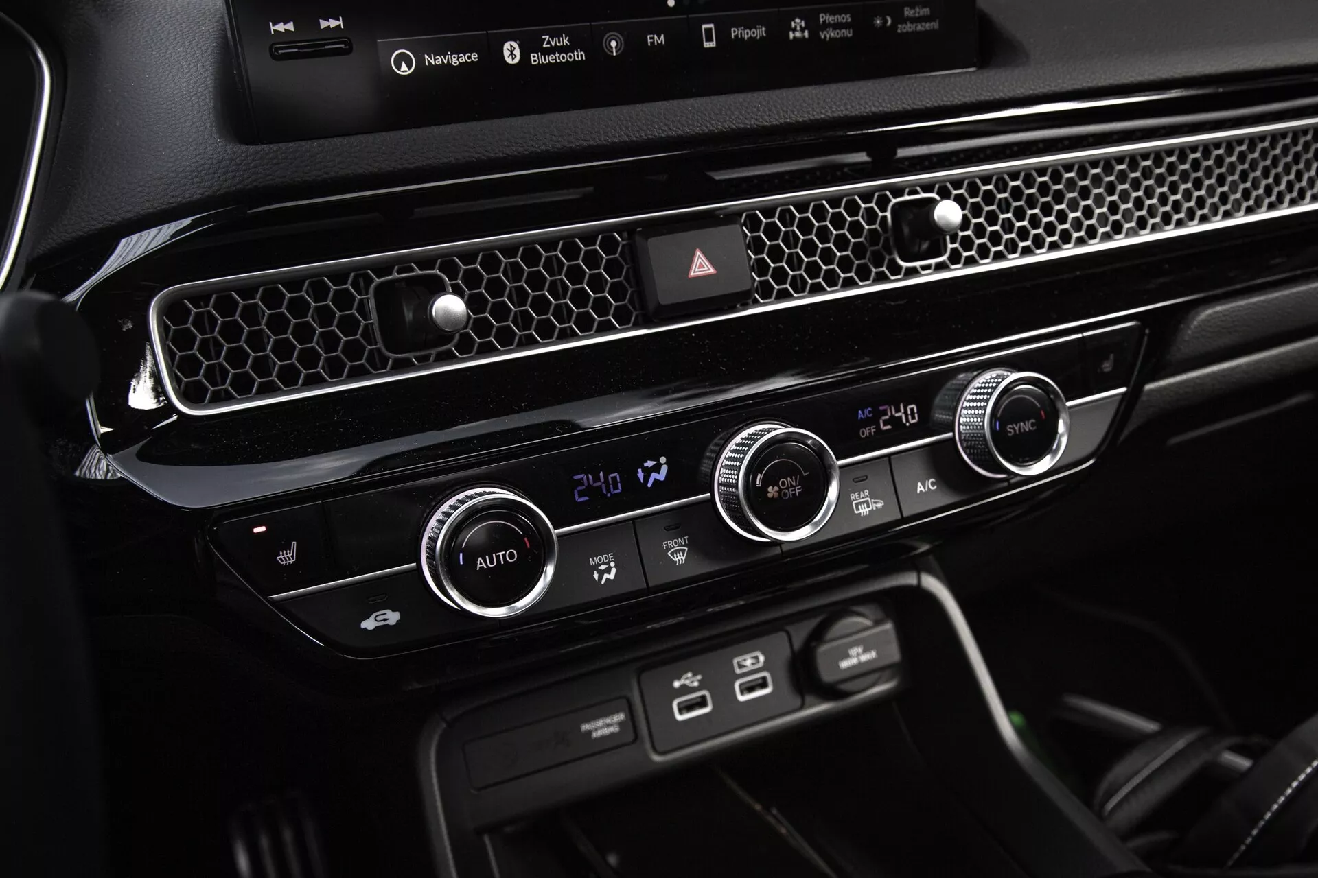 Console centrale et unité de contrôle climatique de la Honda Civic 2022 affichant les réglages de température bizonale, aération accentuée de chrome et boutons de fonction dédiés pour un design intérieur moderne et épuré