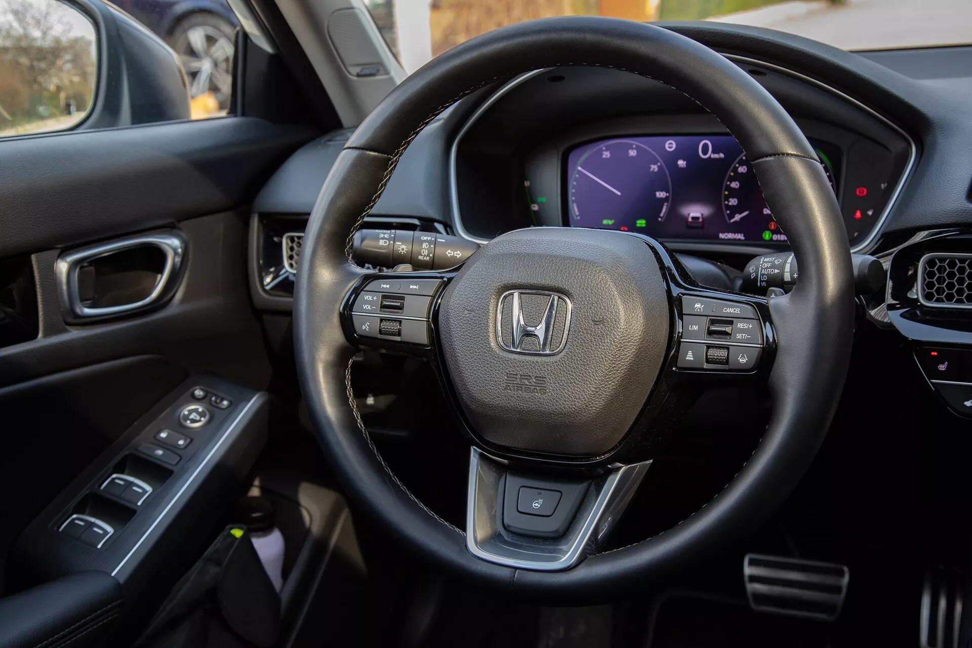 Vue intérieure du Honda Civic 2022 depuis le siège du conducteur, mettant en évidence le volant gainé de cuir avec commandes multifonctions, le tableau de bord numérique, une partie de la console centrale avec écran tactile, et les commandes sur la porte du conducteur pour une exposition complète des fonctionnalités technologiques modernes et du design luxueux du véhicule.