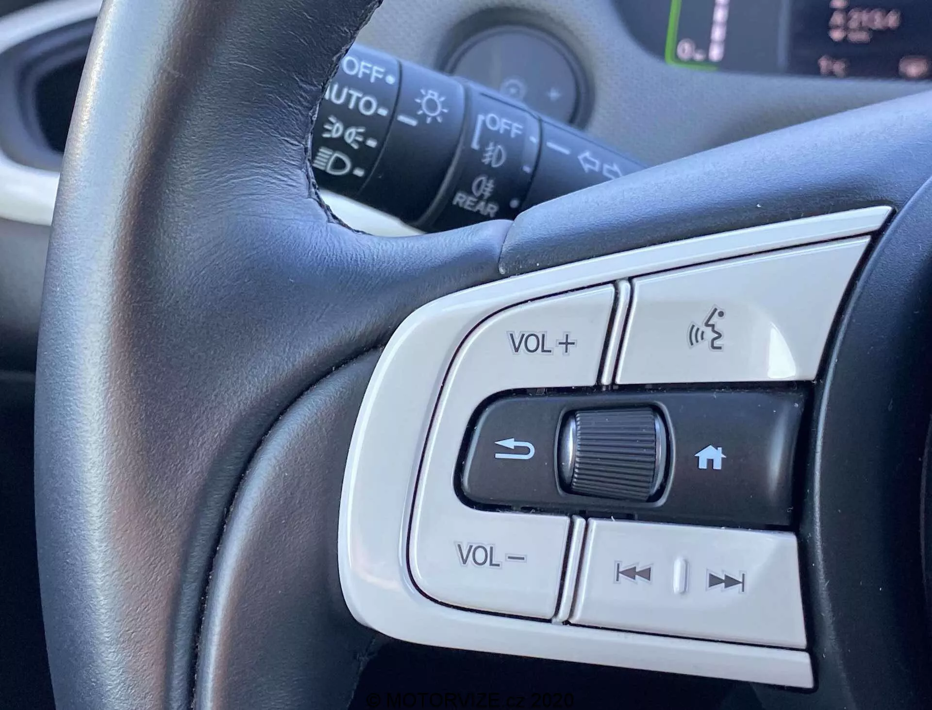 Vue rapprochée des commandes montées sur le volant de la Honda Jazz Crosstar 2020 montrant le réglage du volume, le système téléphonique mains libres et les boutons potentielles de contrôle de régulateur de vitesse ou de sélection de piste audio. Focus central sur le volant en cuir avec garniture argentée soulignant le confort et le design élégant.