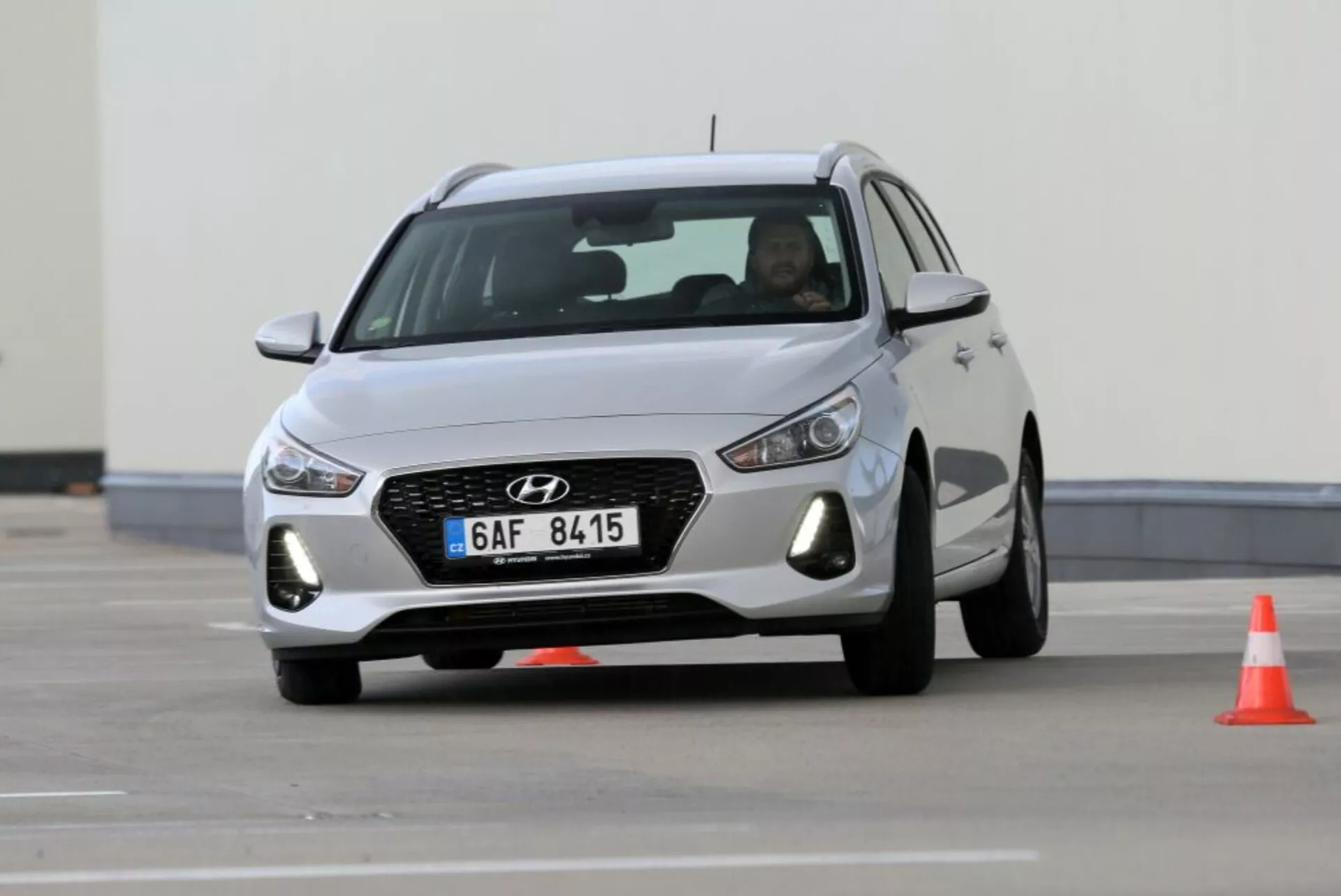 Hyundai i30 N de 2017 en mouvement, présentant sa grille avant avec motif hexagonal et contour chromé, phares LED et design aérodynamique avec jantes alliage, capturée sur un parcours de conduite