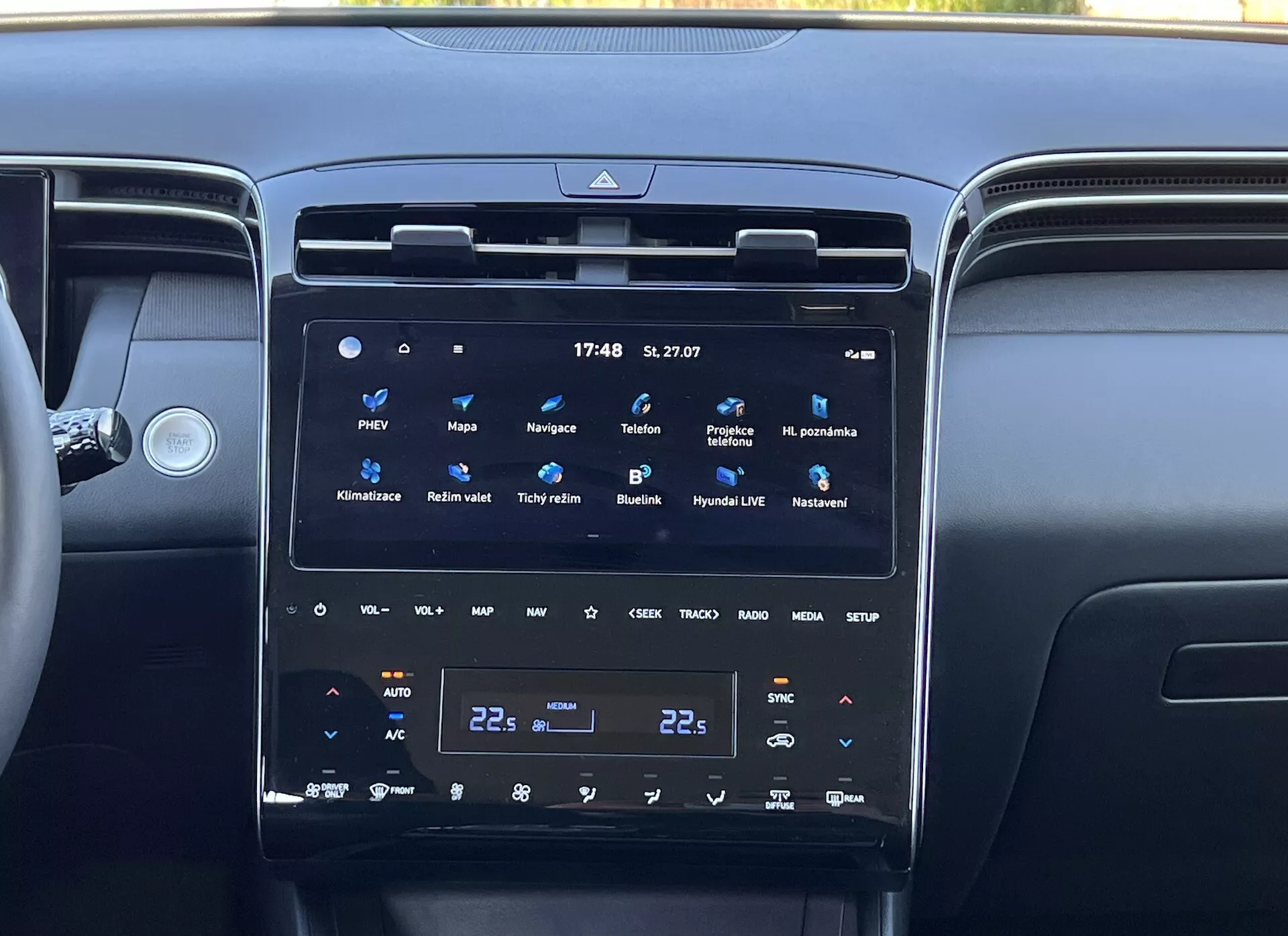 Intérieur du Hyundai Tucson 2020 montrant la console centrale avec un grand écran tactile vertical du système d'infodivertissement, contrôle climatique bi-zone et bouches d'air environnantes, reflétant la technologie moderne du véhicule et le luxe