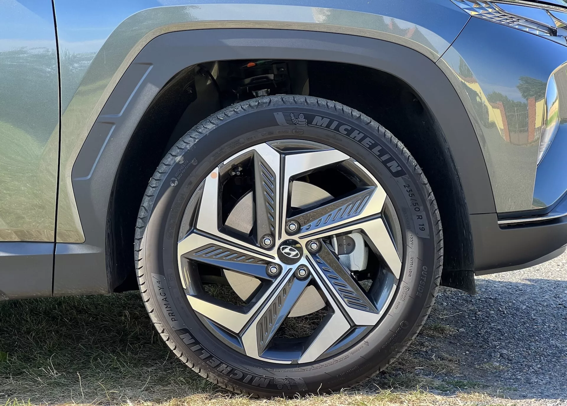 Vue rapprochée de la roue avant et d'une partie de l'aile de la Hyundai Tucson 2020, présentant un pneu Michelin et un design de jante en alliage dynamique à multiples branches, mettant en avant l'esthétique automobile moderne et le branding