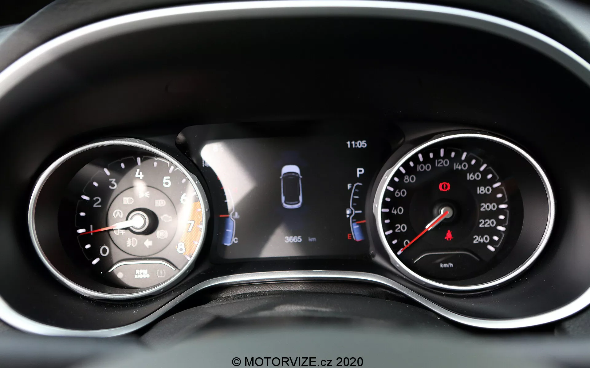 Vue rapprochée du tableau de bord du Jeep Compass 2017 avec une combinaison de cadrans analogiques et d'un écran numérique. À gauche, un compteur de vitesse analogique marqué jusqu'à 260 avec une aiguille pointant juste au-dessus de 0. L'affichage numérique central comprend un graphique de la voiture avec des capteurs et deux portes ouvertes, indiquant l'assistance au stationnement et l'état du véhicule. Une horloge affiche 11:05. À droite, un compte-tours analogique avec une zone rouge commençant avant 7, marqué jusqu'à 8 (par incréments de 1 000 tr/min). Des voyants d'avertissement supplémentaires et des icônes sont visibles, faisant de cette représentation bien éclairée et claire des lectures modernes et traditionnelles du véhicule et des technologies d'assistance au conducteur.