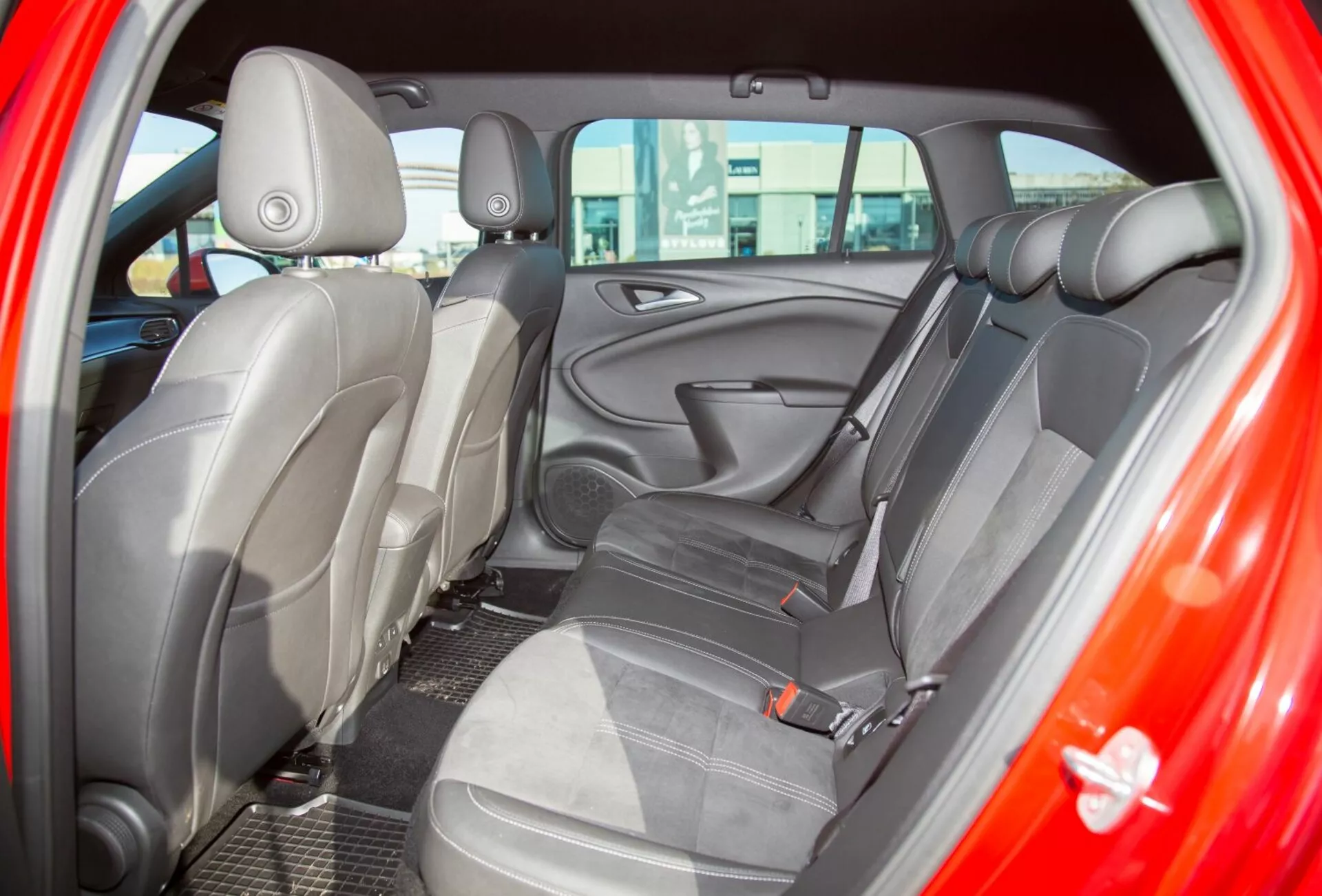 Gros plan sur l'intérieur d'une Kia Ceed de 2009 montrant le siège arrière vu depuis la porte arrière côté conducteur, mettant en avant une garniture en tissu bicolore et une conception de siège ergonomique pour un confort amélioré
