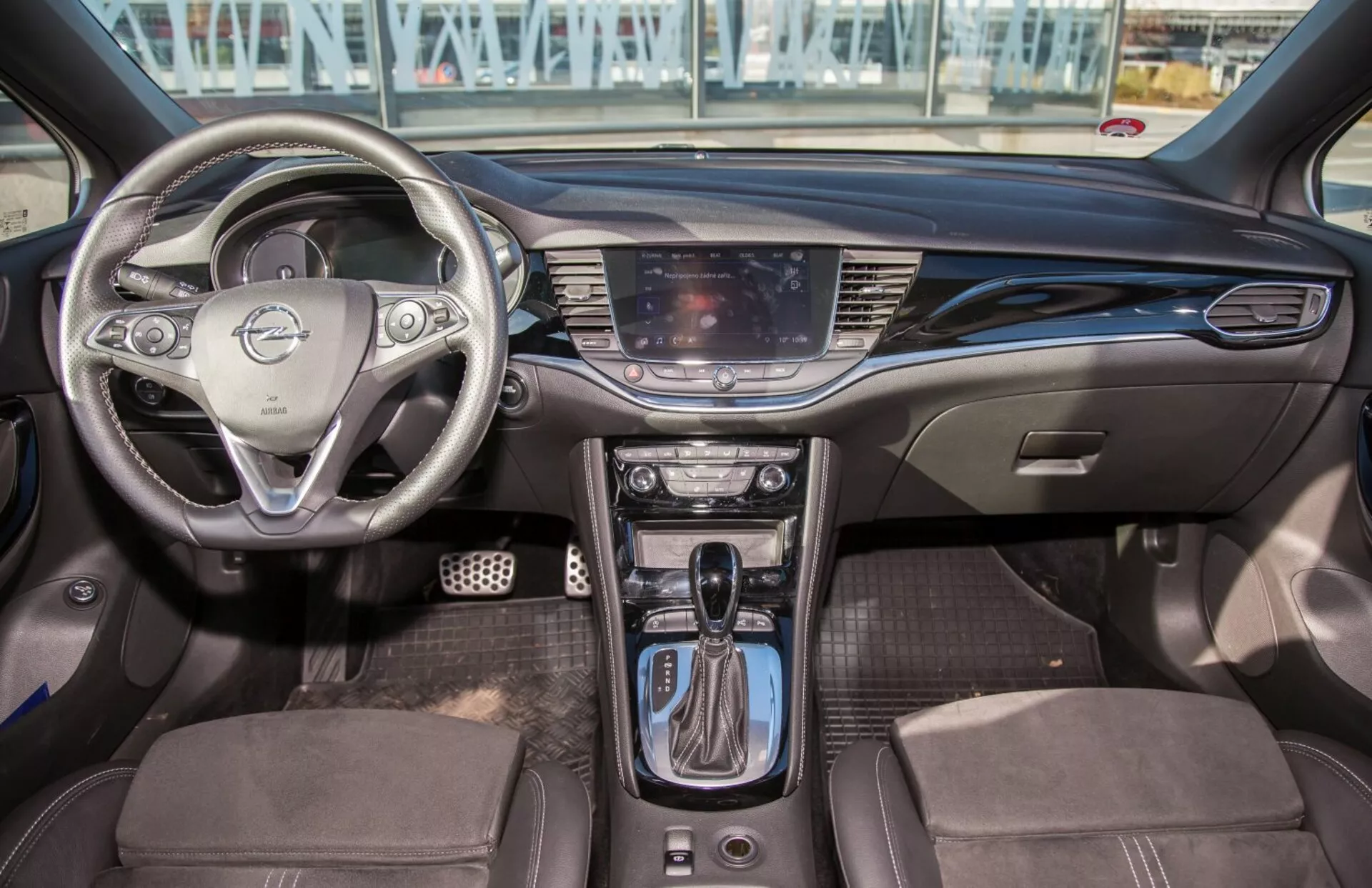 Intérieur de la Kia Ceed 2009 présentant volant multifonction, système d'infodivertissement tactile, commandes de climatisation bi-zone, levier de vitesse automatique, sièges bi-ton avec garniture, et design moderne de la cabine avec aménagements technologiques