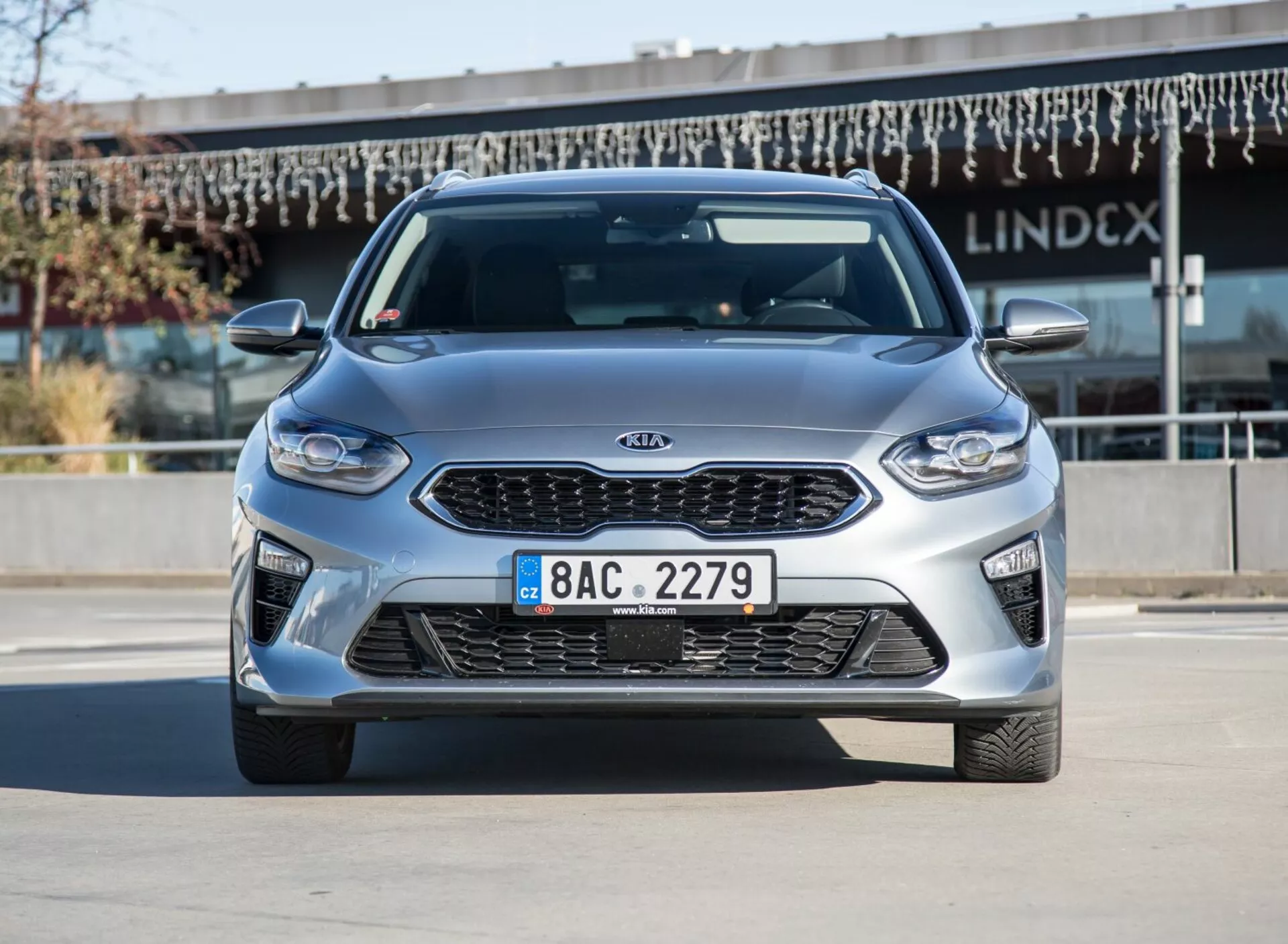 Modèle Kia Ceed 2009 en argent métallisé, vue de face et de côté par une lumière diurne claire, illustrant les jantes en alliage et la conception aérodynamique