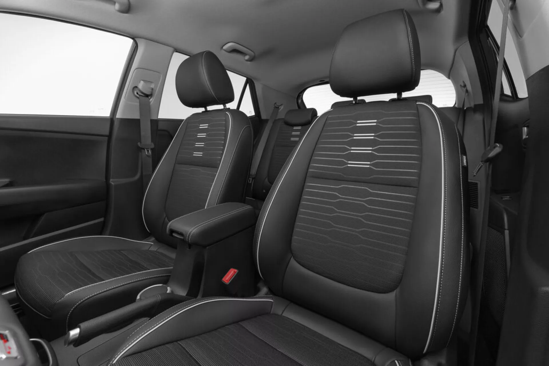 Vue en angle élevé de l'intérieur avant de la Kia Stonic 2017 présentant des sièges en similicuir noir avec coutures horizontales, console centrale et points de verrouillage de ceinture de sécurité rouges axés sur la conception et la disposition