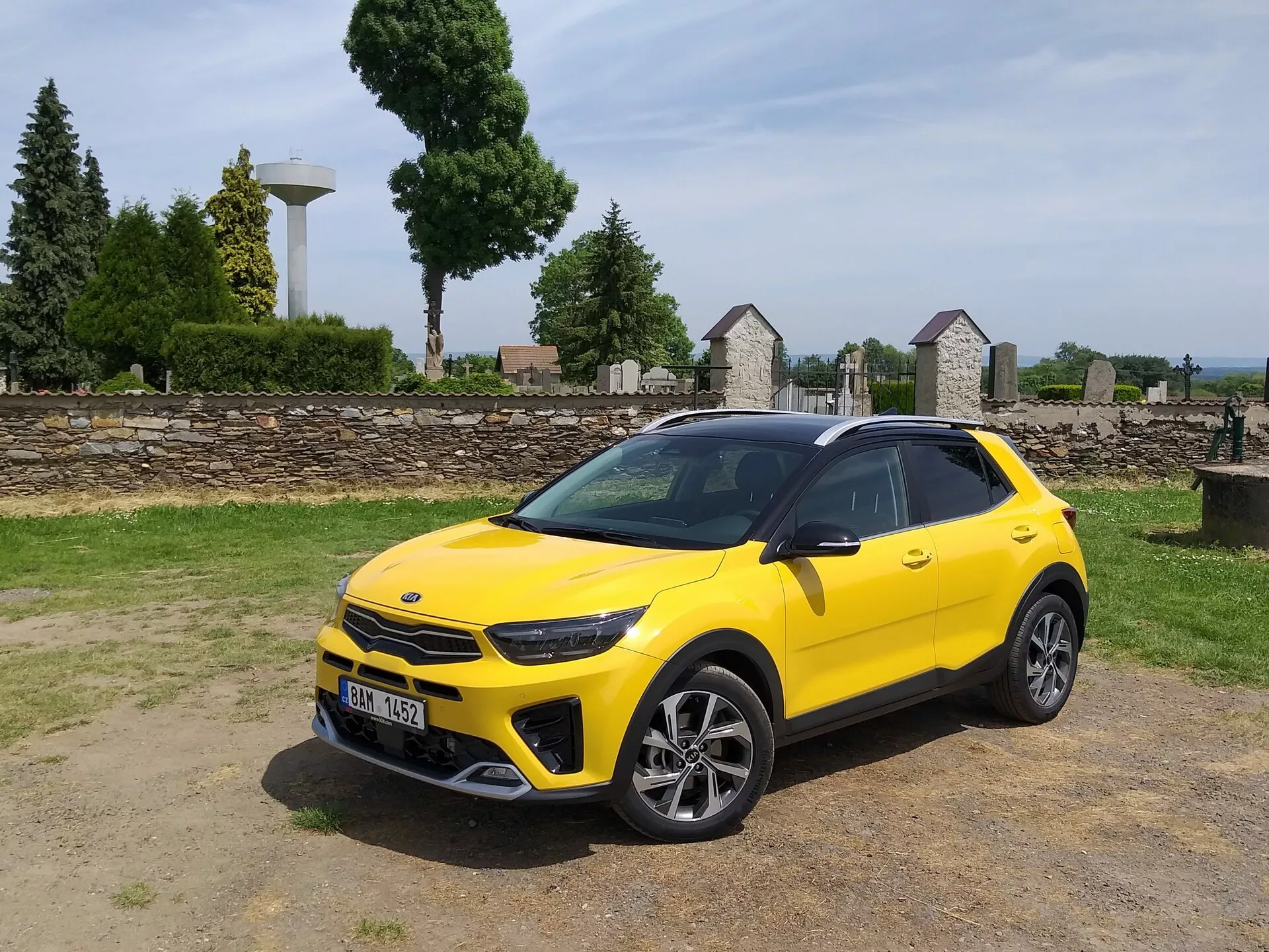 Kia Stonic 2017 en jaune vif, présentant sa grille avant, ses phares à LED, son pare-choc avant sportif et son profil latéral élégant avec des jantes en alliage à rayons multiples et des barres de toit, soulignant l'esthétique de crossover compact et les caractéristiques de conception avancées du véhicule.