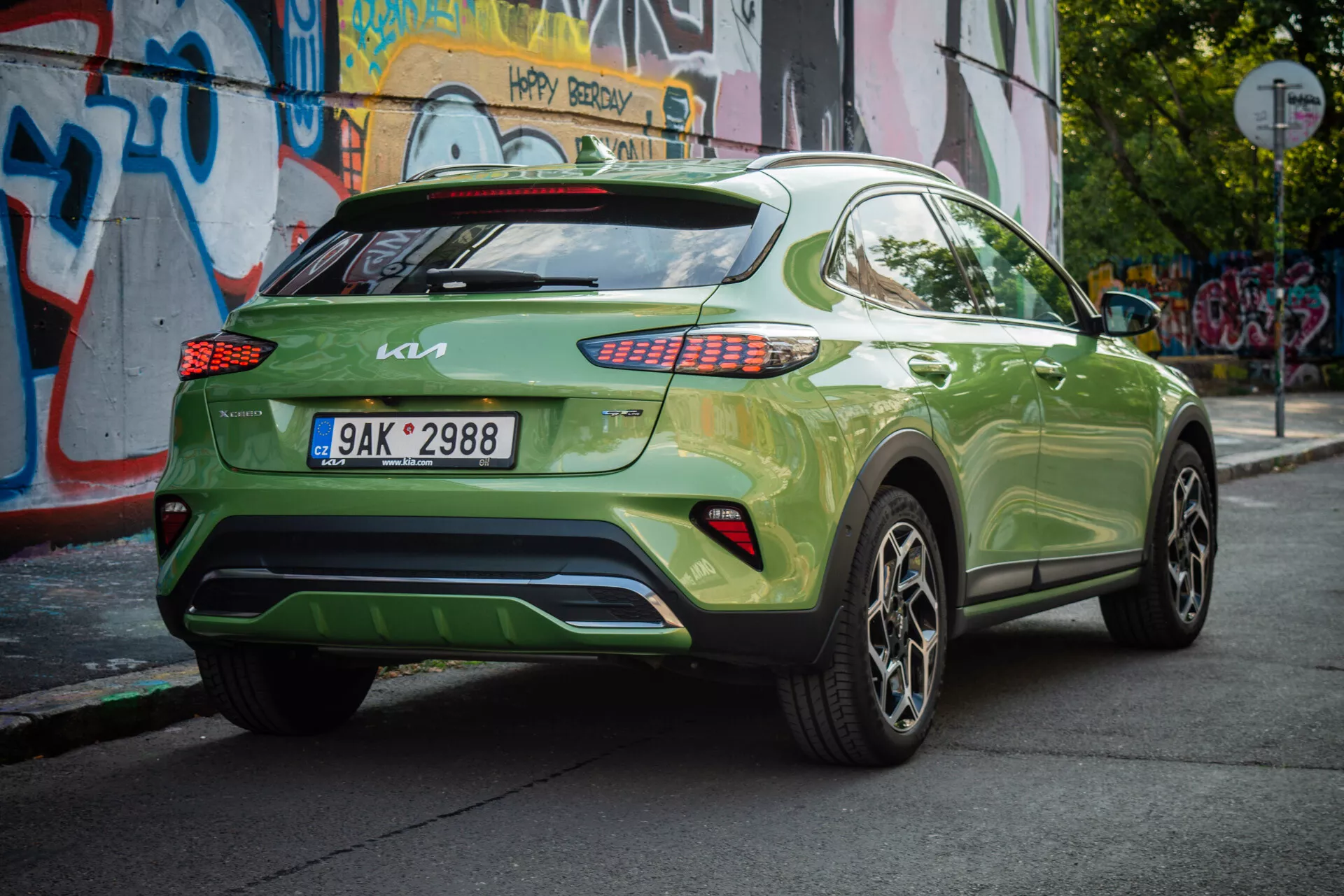 Kia XCeed 2022 en vert vibrant, présentant son angle arrière trois quarts avec plaque d'immatriculation européenne, feux arrière LED, jantes en alliage et fond urbain.