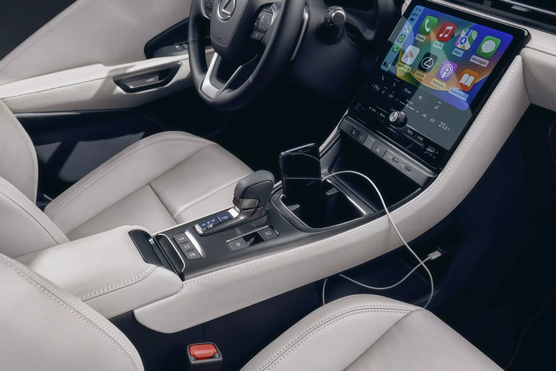 Intérieur du Lexus LBX 1ère génération 2024 présentant une vue détaillée de la console centrale avec un écran tactile vertical, un levier de vitesse automatique et un revêtement en cuir de luxe