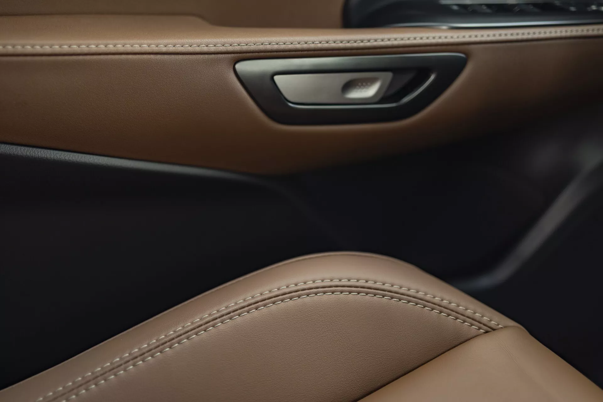 Vue détaillée de l'intérieur du Lexus LBX 2024 montrant un garnissage de porte en cuir marron luxueux, un design de siège ergonomique et des caractéristiques d'éclairage ambiant