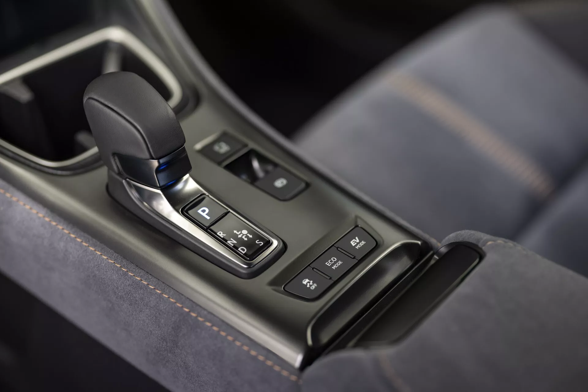 Zone de levier de vitesse automatique de Lexus LBX 2024 1ère génération dans la console centrale avec indicateur de position de stationnement, entourée d'un panneau brillant avec boutons et finition argentée, avec détails en cuir