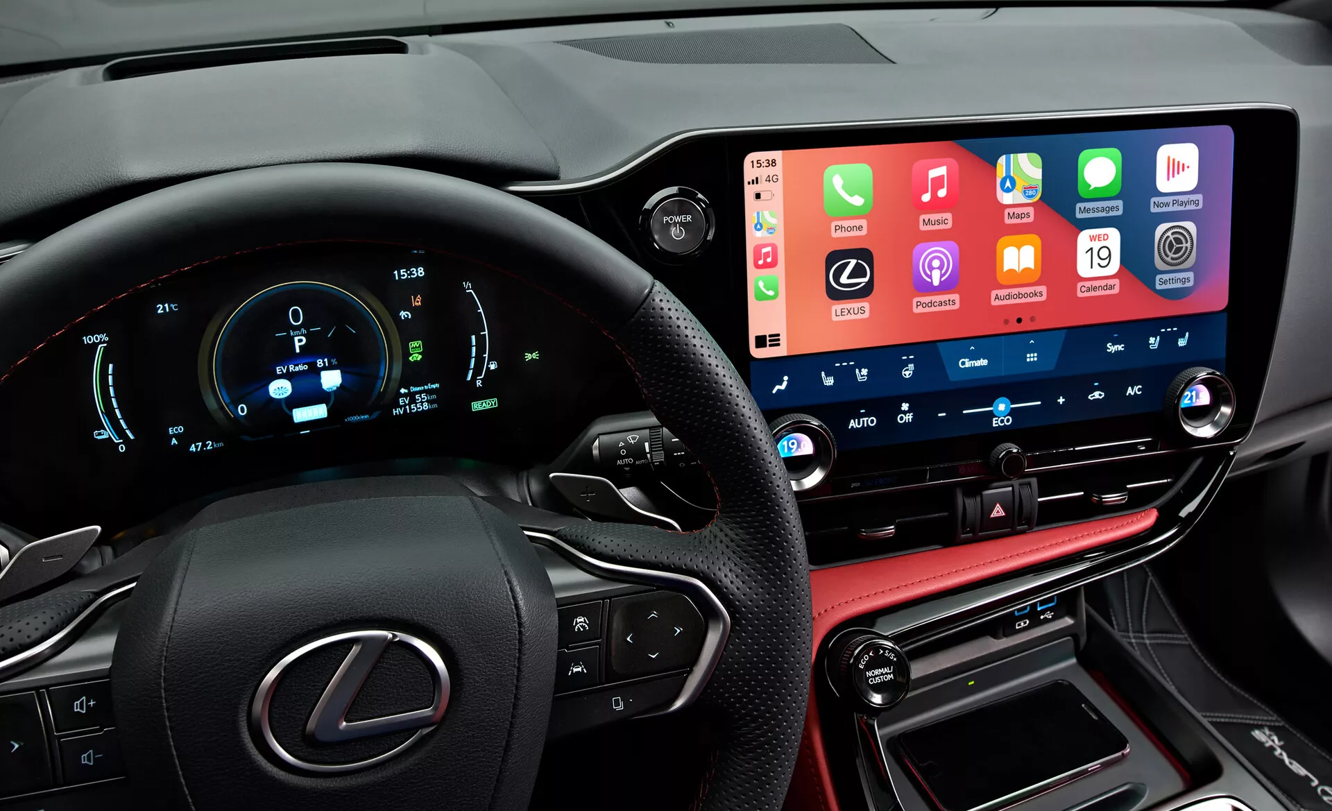 Vue intérieure d'une Lexus NX 2021 présentant un tableau de bord moderne et high-tech depuis la perspective du conducteur. À gauche, on aperçoit partiellement le volant avec le logo Lexus et les boutons multifonctions. Le tableau de bord numérique affiche la vitesse, les tours par minute et d'autres métriques en bleu et blanc. Au centre, l'écran tactile d'infodivertissement large et proéminent intègre les fonctionnalités des smartphones. En dessous, les boutons et cadrans de contrôle de la climatisation avec des affichages numériques de la température. La partie inférieure comprend une console en cuir avec le levier de vitesses et les ports de connectivité, reflétant les finitions luxueuses du véhicule.