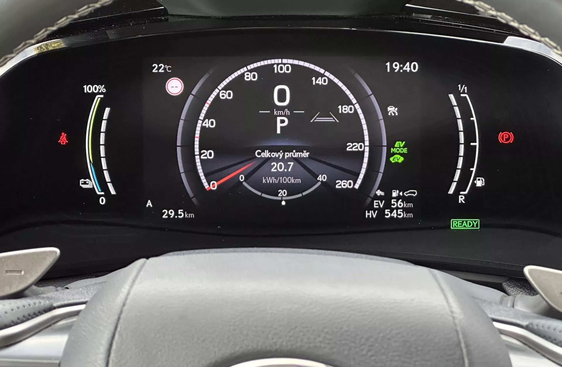 Vue rapprochée du tableau de bord numérique de la Lexus NX 2021, présentant l'indicateur de charge de la batterie, le compteur de vitesse, le jauge de puissance, et divers indicateurs de modes de conduite du point de vue du conducteur.