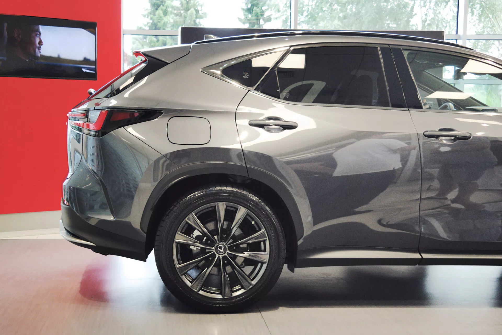 L'image montre la vue arrière trois quarts d'un SUV crossover compact ou de taille moyenne moderne, mettant en avant le côté droit. Les caractéristiques visibles comprennent des roues en alliage à plusieurs rayons, des feux arrière à LED, une ligne de toit inclinée, des vitres arrière teintées, une finition de peinture métallique, des lignes de carrosserie nettes, un spoiler arrière intégré, une antenne en forme d'aileron de requin et un bas de caisse en plastique. Le design du véhicule indique un profil sportif et aérodynamique, approprié pour des discussions sur le design automobile, la technologie et les caractéristiques.
