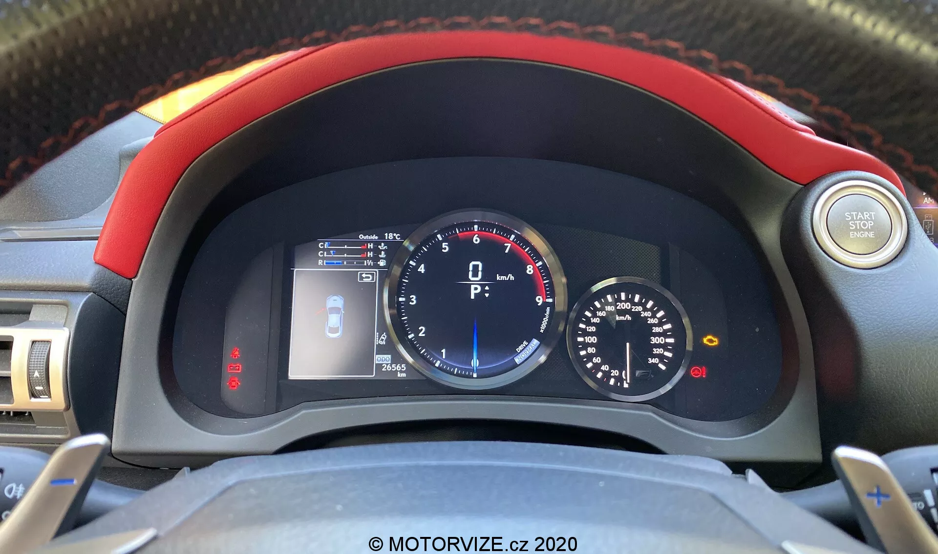 Vue intérieure de la Lexus RC 2016 concentrée sur le tableau de bord depuis la perspective du conducteur, montrant un volant avec des boutons de commande audio et de régulateur de vitesse, un petit écran LCD affichant un indicateur de porte ouverte, une jauge de température du moteur, un grand compteur de vitesse analogique avec affichage numérique central, une jauge de carburant et un petit tachymètre avec l'aiguille au repos.
