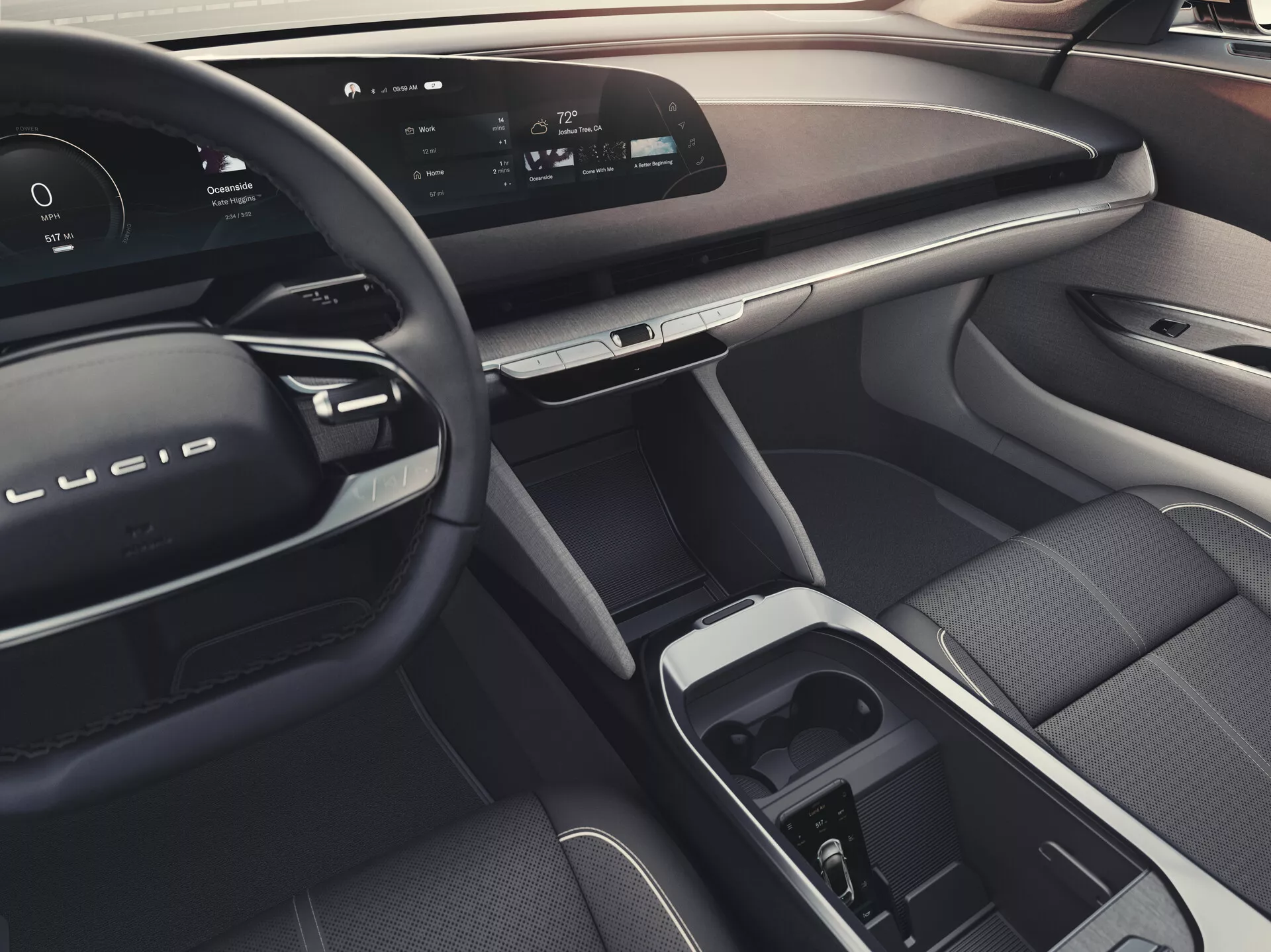Vue intérieure de la Lucid Air 2022 (1ère génération) depuis le siège arrière, montrant un tableau de bord élégant avec un écran numérique continu, volant moderne avec commandes intégrées, matériaux luxueux, écran tactile central et sélecteur de vitesse dans la console centrale, siège passager avant ergonomique, commandes avancées des fenêtres et des rétroviseurs sur la porte passager, ambiance générale suggestive des fonctionnalités d'éclairage ambiant.