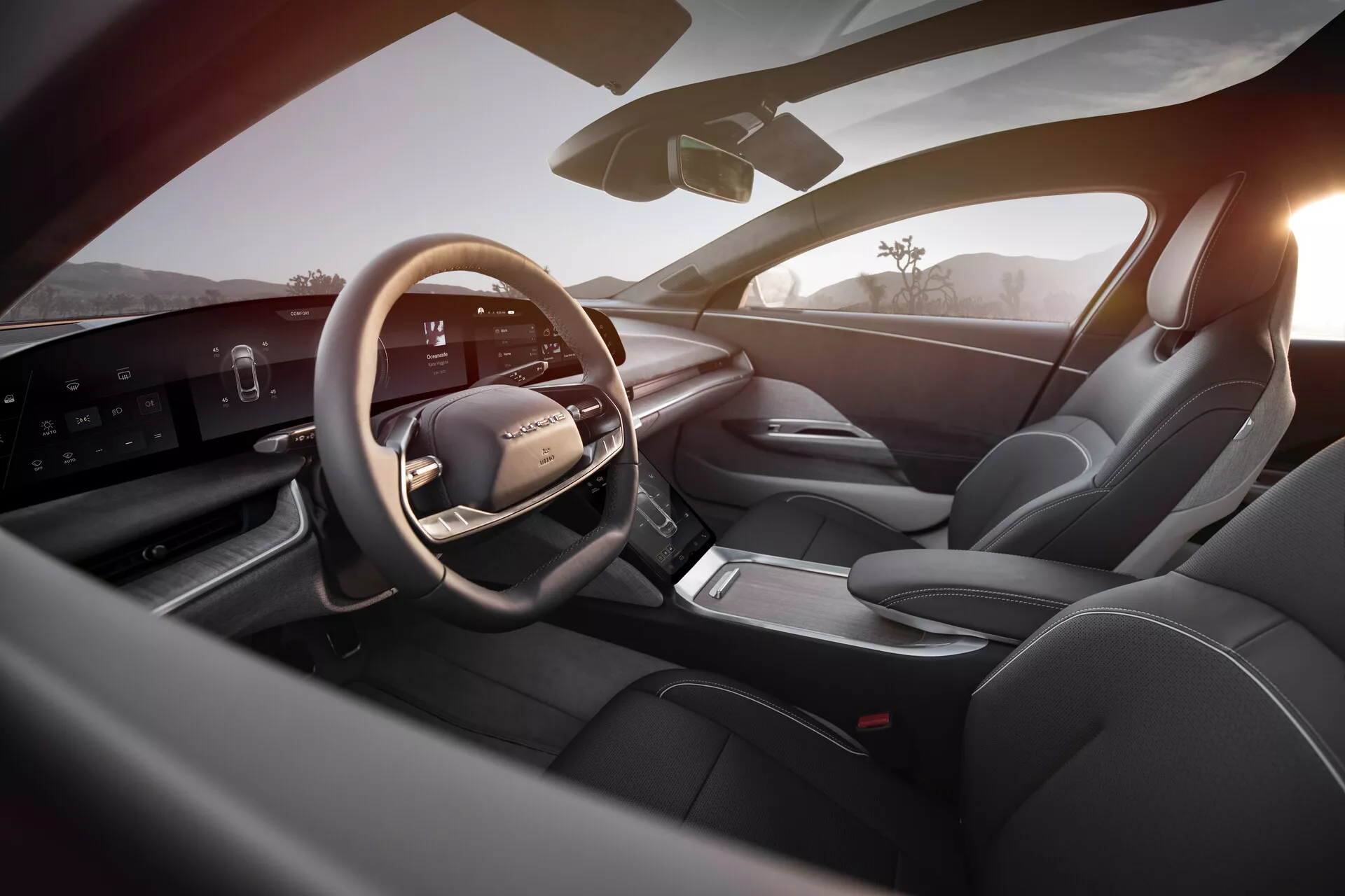 Vue intérieure de la Lucid Air 2022 depuis la perspective du siège arrière droit, montrant un espace conducteur luxueux et moderne. Les éléments clés incluent un volant multifonction en cuir avec commandes intégrées, un élégant tableau de bord numérique horizontal, une console centrale épurée avec sélecteur de vitesses électronique, des sièges sport en cuir, des commandes sophistiquées sur le panneau de porte, et une bonne visibilité générale avec un rétroviseur latéral et un pare-brise. L'intérieur bien éclairé met en avant la technologie de pointe et le design premium, accentué par la lumière extérieure chaude suggérant l'aube ou le coucher du soleil.