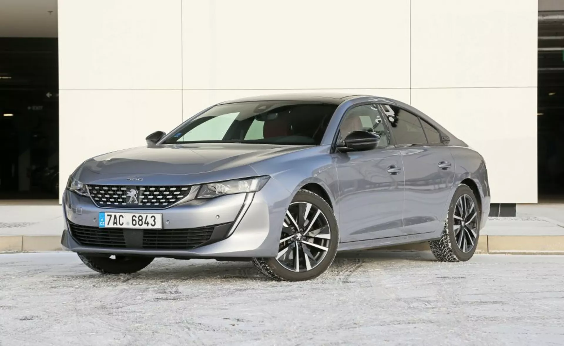 Sedan Mazda 6 de 2013 garé à l'extérieur avec une légère couverture de neige, présentant un design élégant et des caractéristiques modernes comme des phares LED et des accents chromés