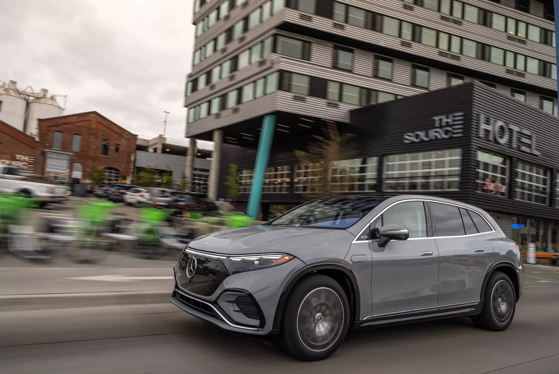 Une prise de vue dynamique du Mercedes EQS-SUV 2022 en mouvement, avec un effet de flou panoramique qui met en valeur la vitesse du véhicule. La calandre avant, les phares à LED, les jantes en alliage et le design aérodynamique du capot et de la ligne de toit sont proéminents, soulignant ses éléments sophistiqués et luxueux. La finition métallique du véhicule et son style crossover avec des fenêtres élégantes sans cadre et des rétroviseurs aérodynamiques ajoutent à son attrait moderne et haut de gamme.