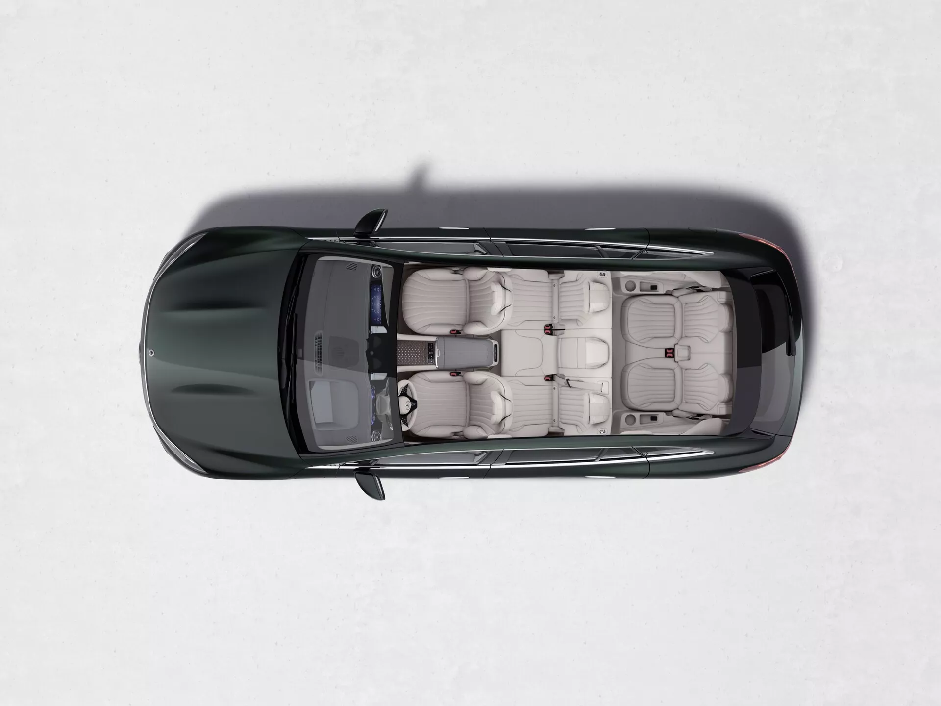 Vue de dessus du Mercedes EQS SUV 2022, mettant en valeur son toit ouvrant, sa sellerie cuir de couleur claire, sièges individuels avec appuie-têtes, quatre portes avec poignées affleurantes, peinture foncée brillante et rétroviseurs latéraux contrastants sur un fond clair et uniforme.