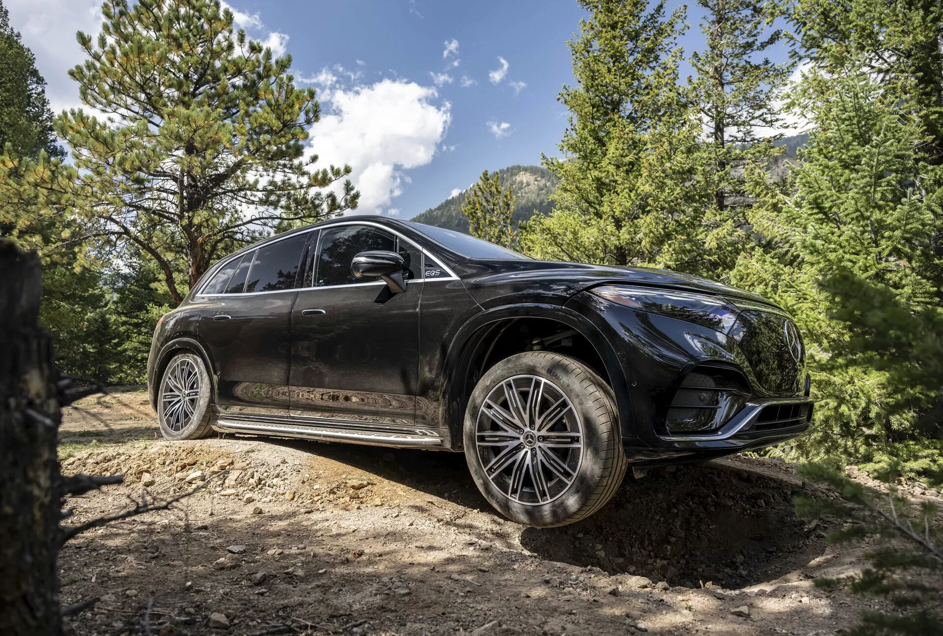 Vue de trois quarts avant du Mercedes EQS SUV 2022, mettant en évidence son design élégant, ses phares LED avancés, son toit panoramique et ses jantes en alliage haut de gamme dans un cadre urbain sophistiqué.