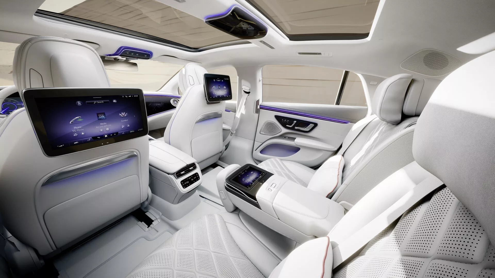 Intérieur du Mercedes-Benz EQS facelift 2024 mettant en valeur le compartiment passager arrière de luxe avec des sièges en cuir blanc premium, des écrans de divertissement avancés et un éclairage d'ambiance élégant