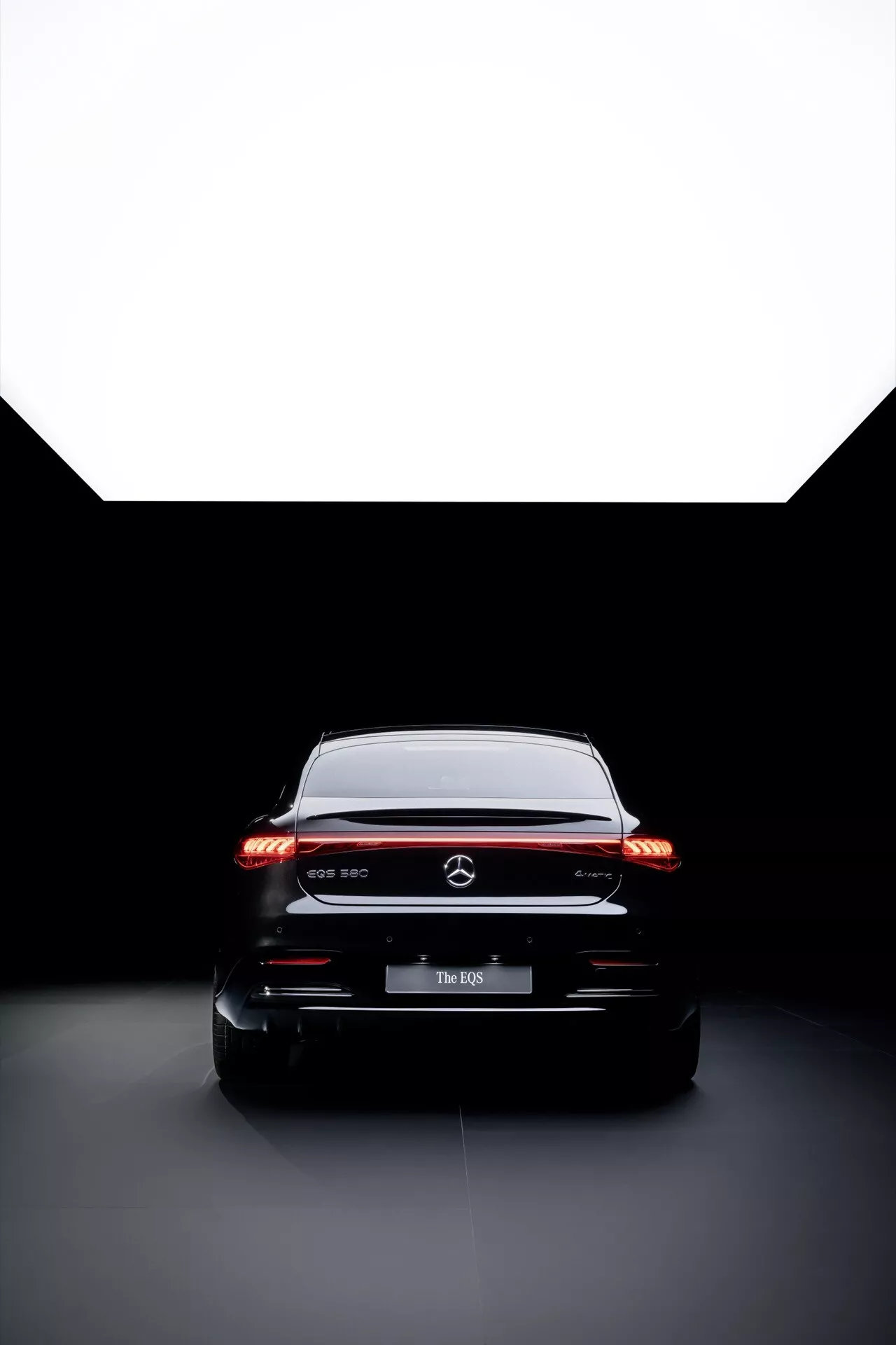 Image studio de la vue arrière de la Mercedes-Benz EQS 2024 présentant les feux arrière LED, le branding premium et l'éclairage à haut contraste pour un examen détaillé de la conception et de la technologie des voitures modernes.