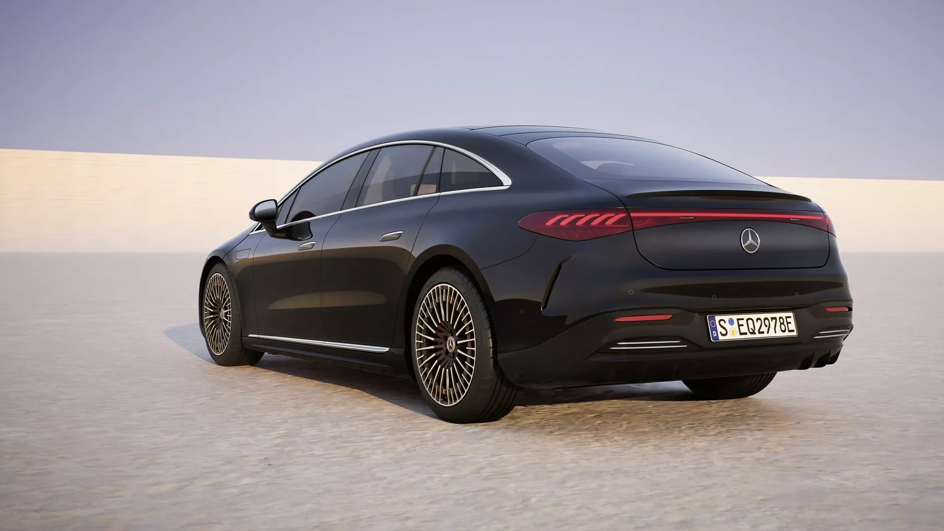 Vue arrière trois quarts de la Mercedes-Benz EQS 2024 (Restylage 297) affichant des feux arrière LED, des roues en alliage aérodynamiques et un toit coupé sur une plaine sablonneuse
