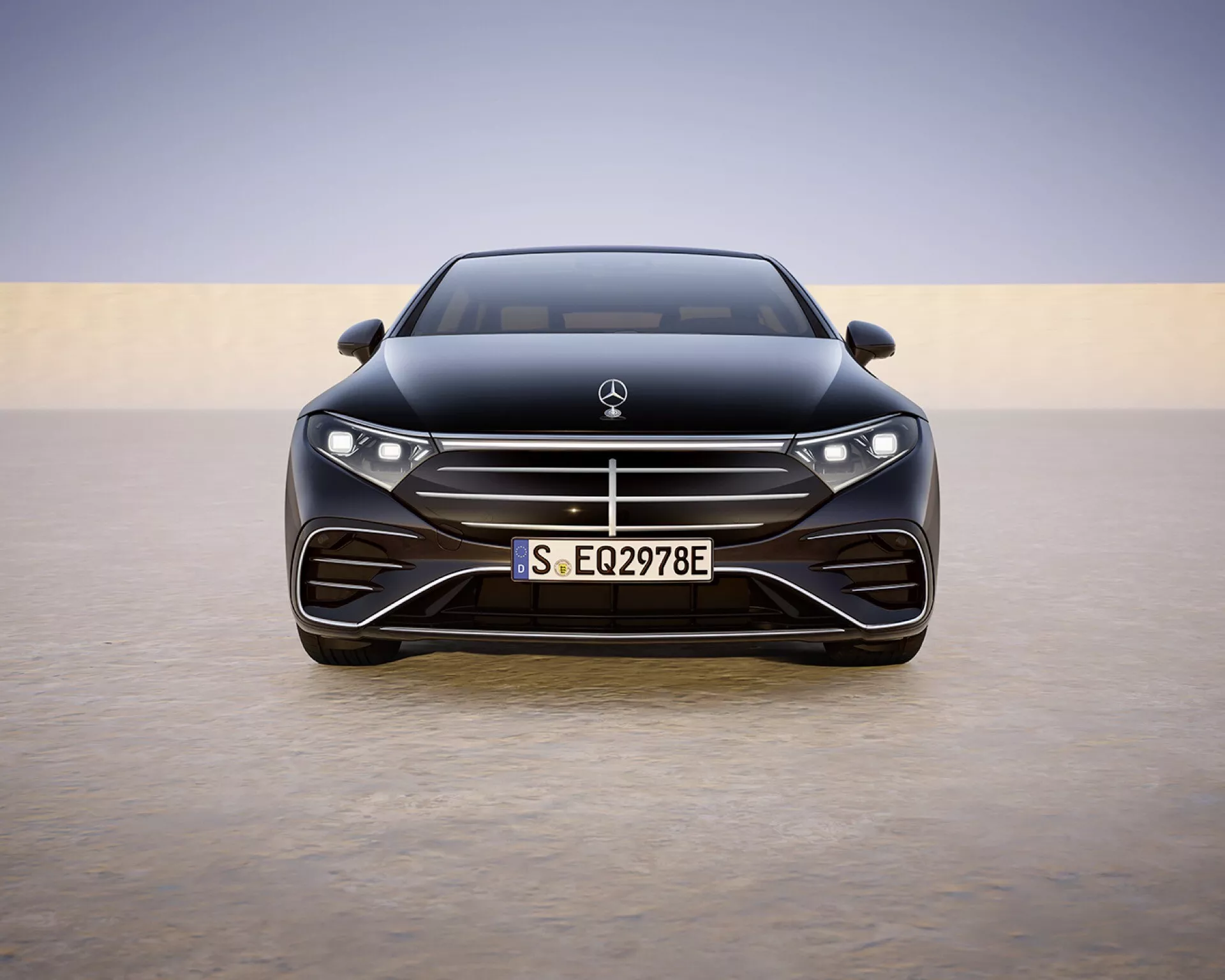 Mercedes-Benz EQS 297 facelift 2024 photographié de face présentant son design avant aérodynamique, ses phares LED et son emblème sur un panneau lisse contre un fond doucement éclairé, illustrant ses caractéristiques de luxe et de véhicule électrique avancé