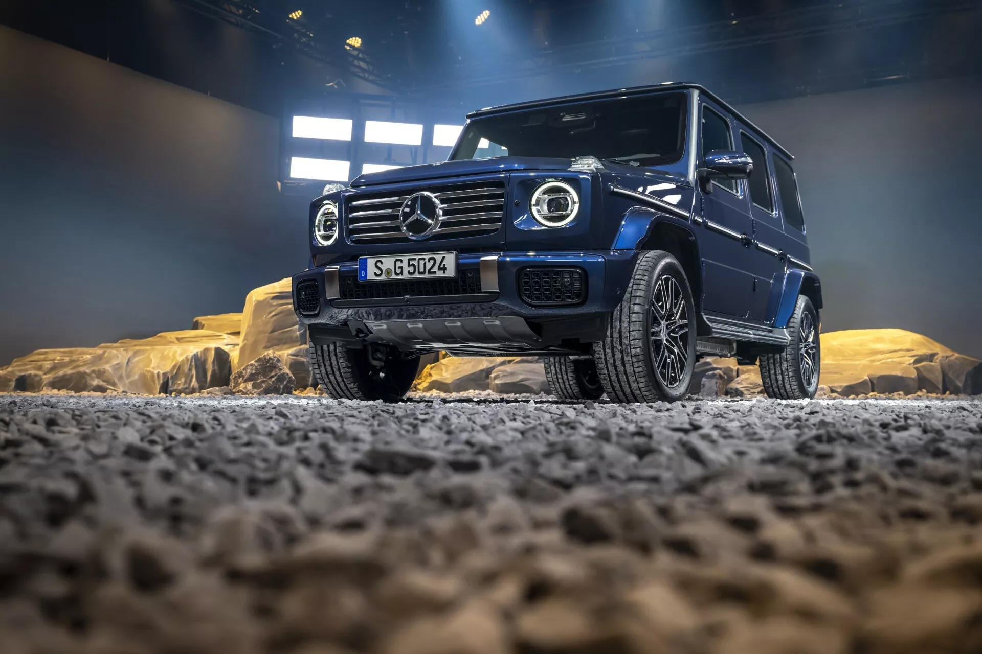 Mercedes-Benz Classe G (G 465) de 2024 en contexte tout-terrain mettant en avant sa stature robuste et ses caractéristiques de luxe avec grille distinctive, phares à LED et jantes au design avancé