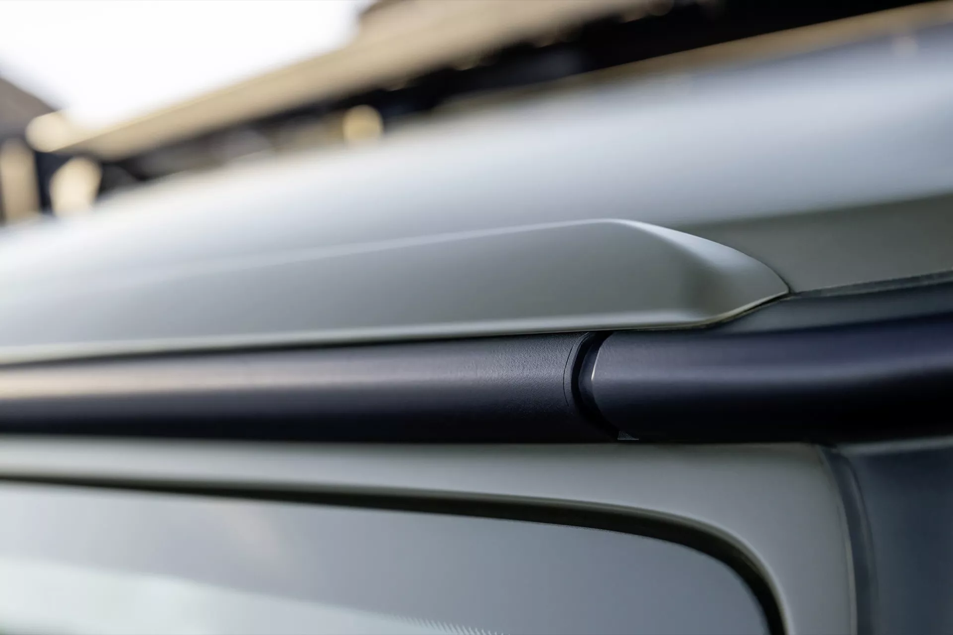 Détail du design extérieur de la Mercedes-Benz Classe G 2024 mettant en lumière une ligne contourée et une carrosserie métallique lisse sous un angle oblique