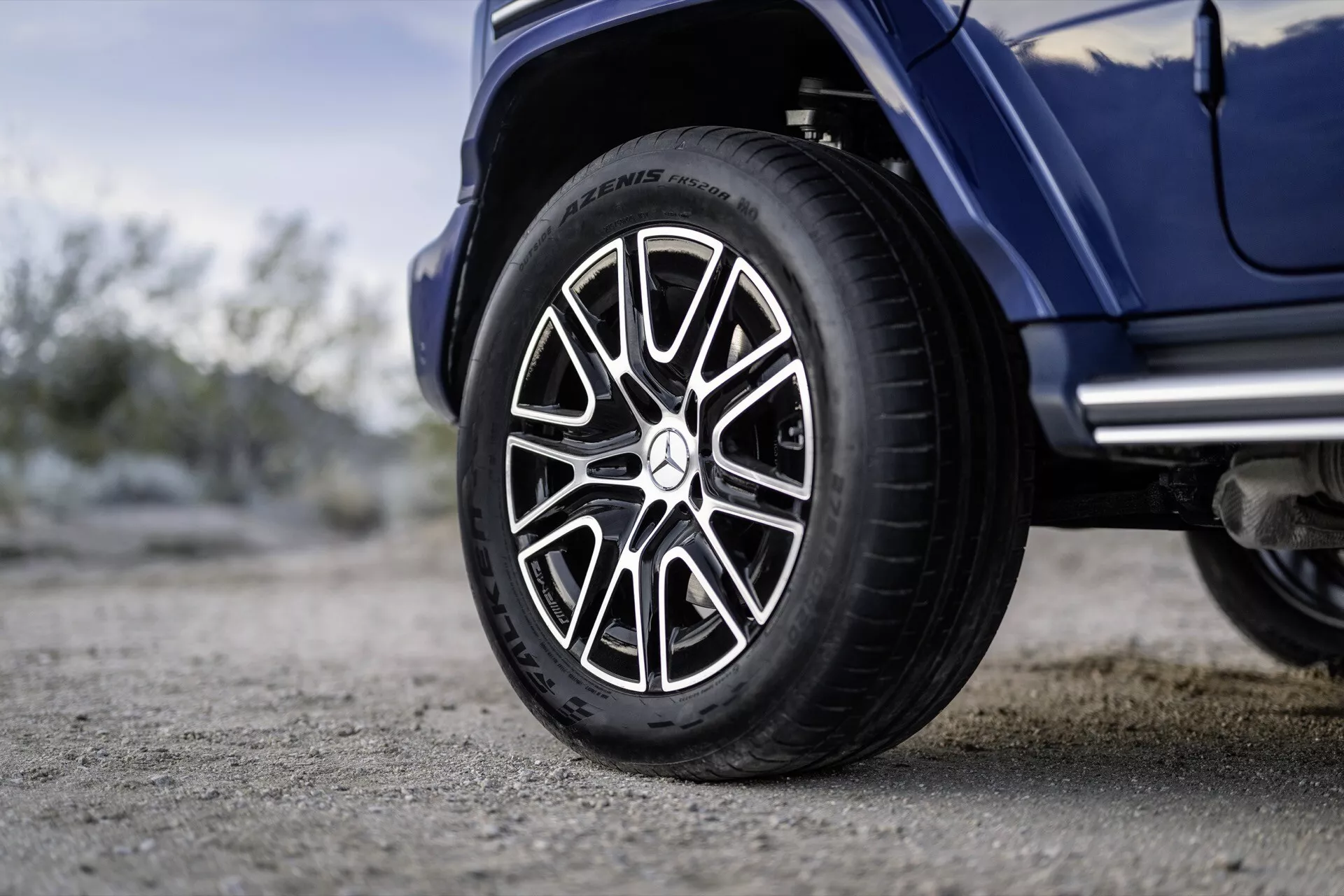 Vue rapprochée de la roue côté droit de la Mercedes-Benz G-Klasse 2024, équipée d'un pneu Michelin et d'un design de jante sportif et complexe, dans un cadre extérieur