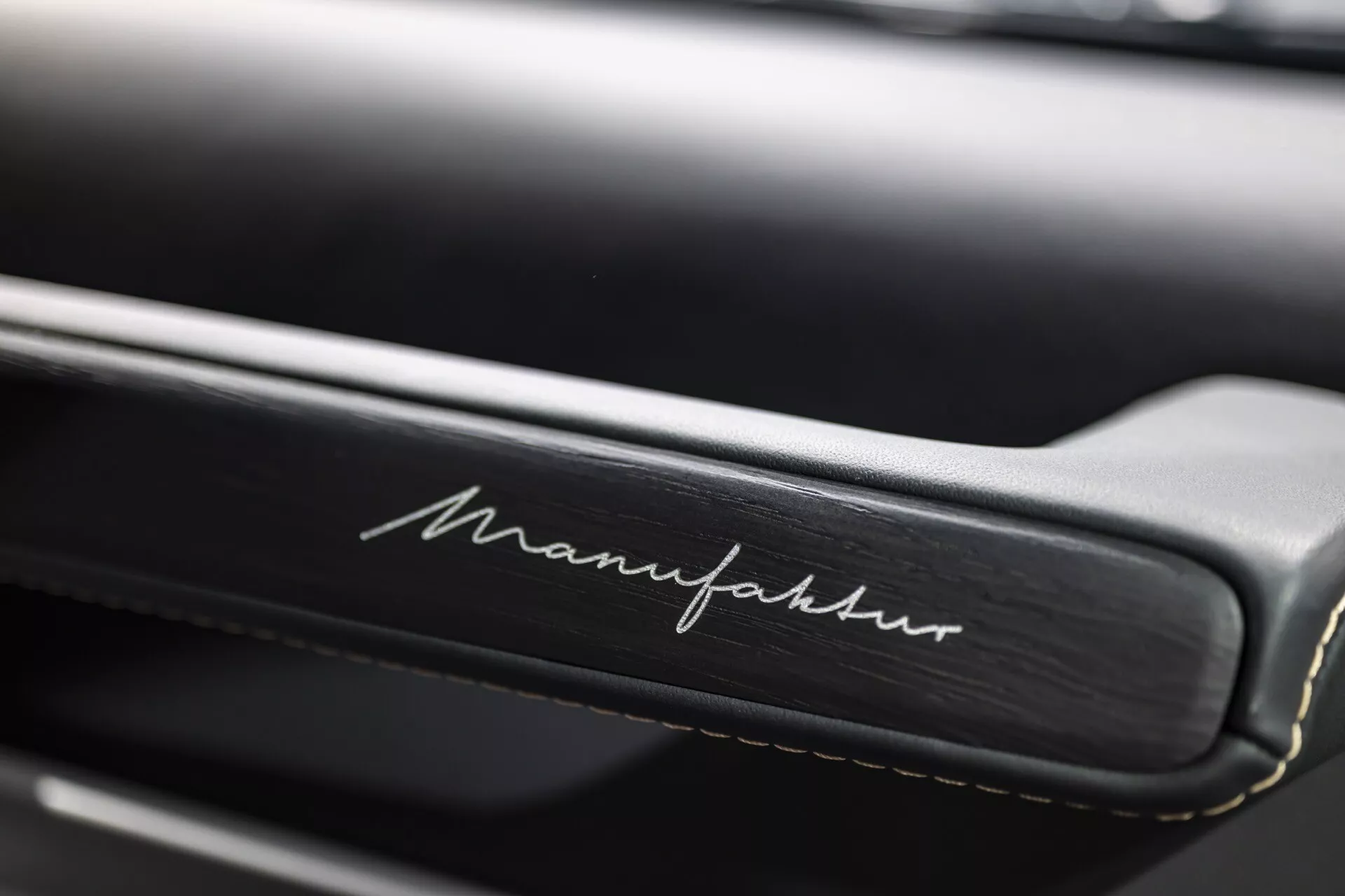 Gros plan sur l'intérieur d'une Mercedes-Benz G-Klasse 2024 montrant des coutures détaillées et une inscription 'Manufaktur' sur cuir, soulignant la personnalisation de luxe