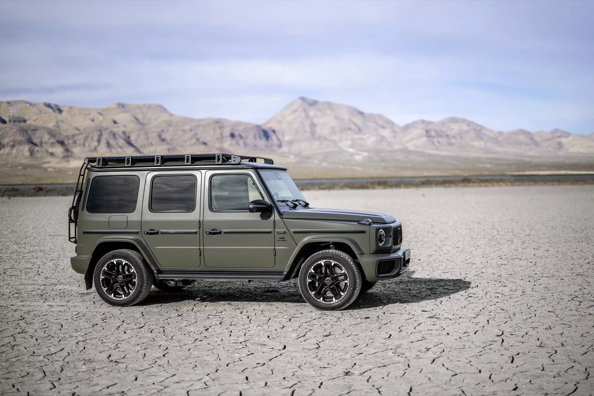 SUV Mercedes-Benz Classe G 2024 en vert olive mat, présentant des phares LED et un design robuste sur fond de désert