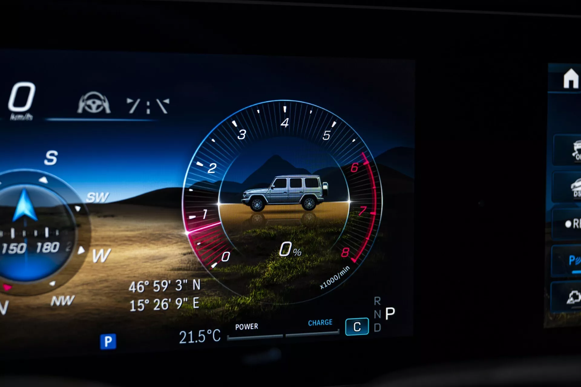 Gros plan sur le tableau de bord numérique de la Mercedes-Benz G-Klasse 2024 montrant le cluster de jauges tout-terrain avec graphique SUV, compte-tours, indicateurs de puissance et de charge, boussole avec GPS et capteur de température extérieure