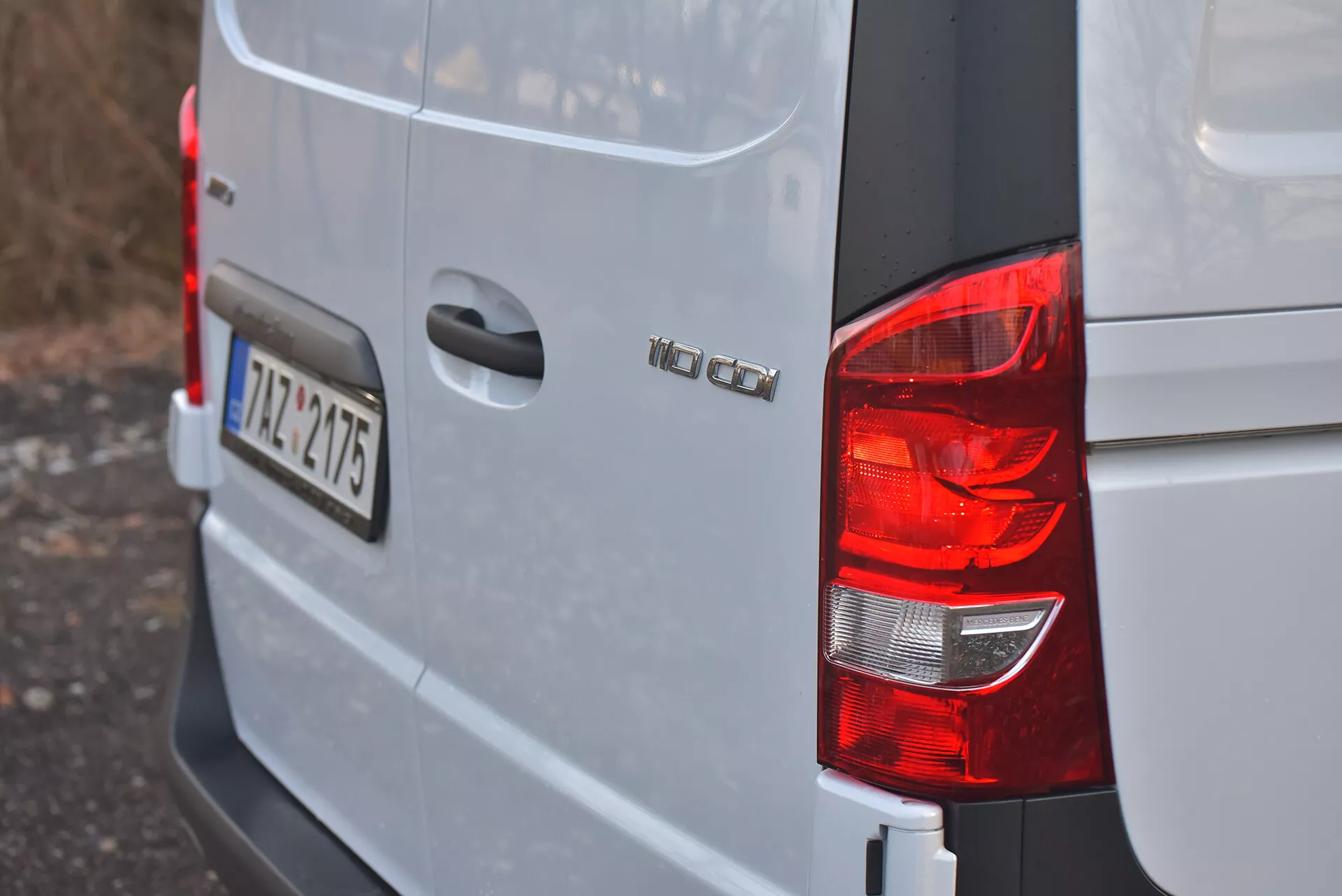 Vue sur le coin arrière droit d'un fourgon Volkswagen Vito 2014 Tourer en argenté ou gris clair montrant le feu arrière, le badge du modèle 'VW CADDY', la plaque d'immatriculation au style européen '12-TZ-4715', et un design de carrosserie carré typique des fourgonnettes de chargement compactes.