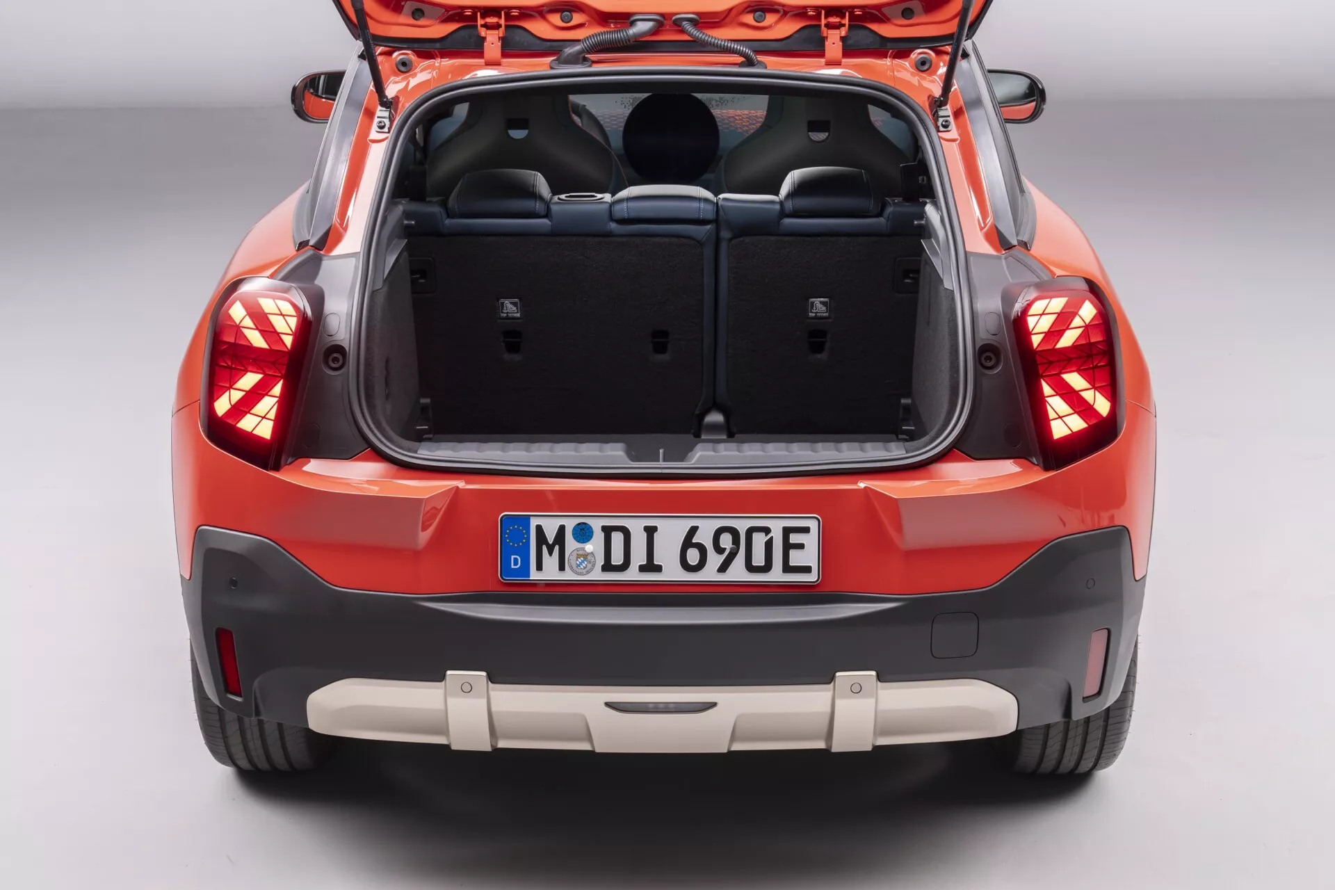 Vue arrière du Mini Aceman (J05) 2024 présentant l'espace de coffre, les feux arrières élégants enveloppants et le design moderne de la hatchback sans marque visible, indiquant des fonctionnalités technologiques potentielles comme des capteurs de collision arrière