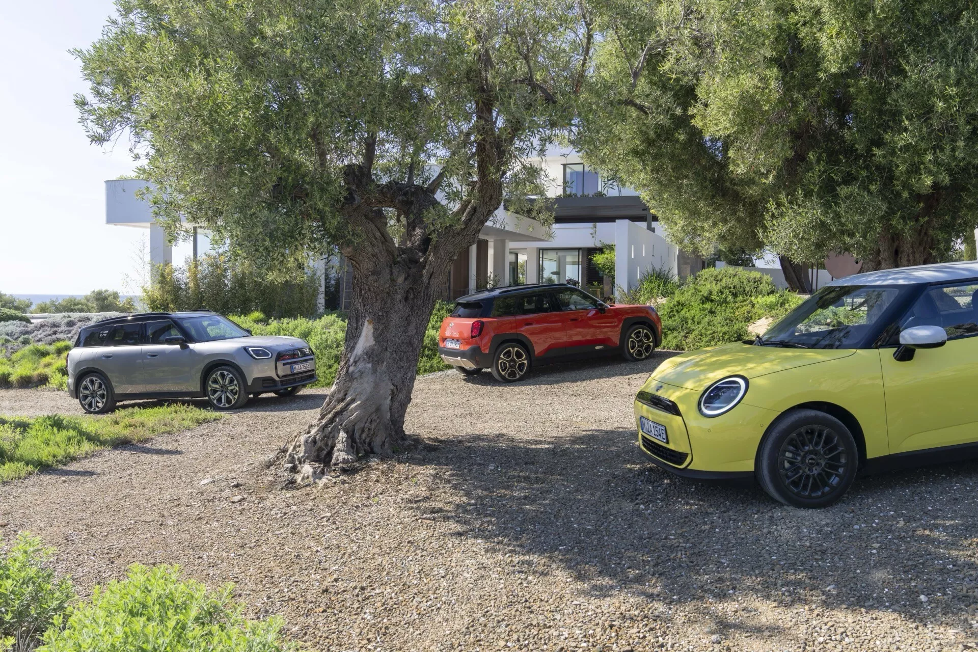 Mini Aceman 2024 (J05) en jaune vif, présentée dans un cadre extérieur pittoresque avec un focus sur son design distinctif, incluant des phares ronds, des roues en alliage modernes et un détail de grille chromée