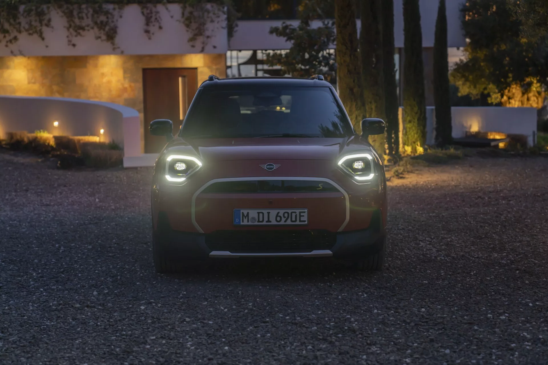 Vue frontale de la Mini Aceman (J05) électrique de 2024 au crépuscule avec phares circulaires allumés et grille minimaliste, démontrant le design moderne des véhicules électriques