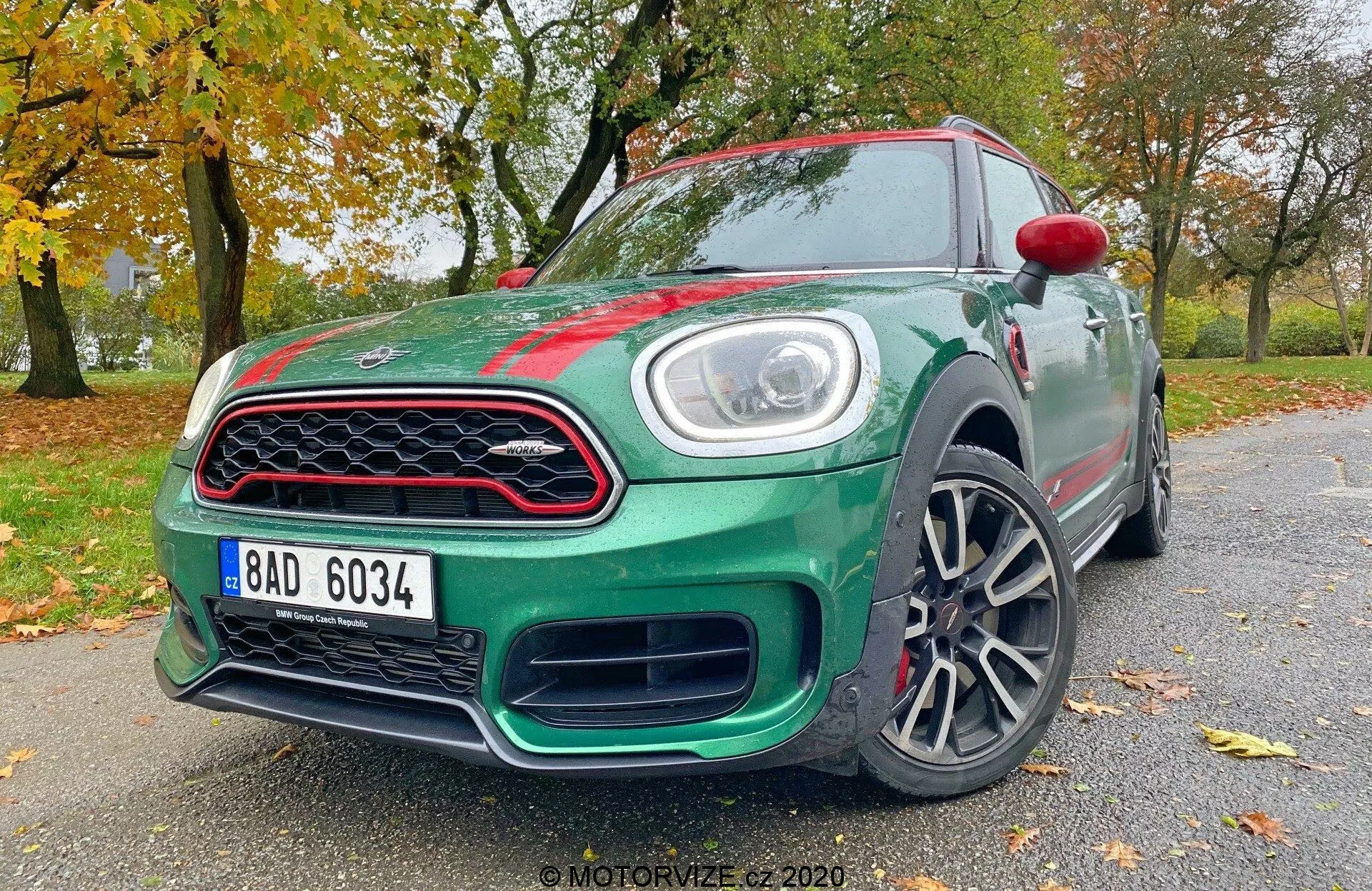L'image montre une voiture hatchback Mini Countryman John Cooper Works de 2020, capturée sous un angle de trois quarts avant bas. Les éléments de conception et de technologie clés sont visibles, y compris les phares à LED, la calandre avant distinctive, le pare-chocs stylisé, les roues en alliage, les rétroviseurs latéraux partiellement visibles avec clignotants intégrés, les lignes aérodynamiques de la carrosserie, les badges et la finition de peinture brillante de la voiture. Cette perspective met en évidence la posture agressive et le design dynamique du véhicule.