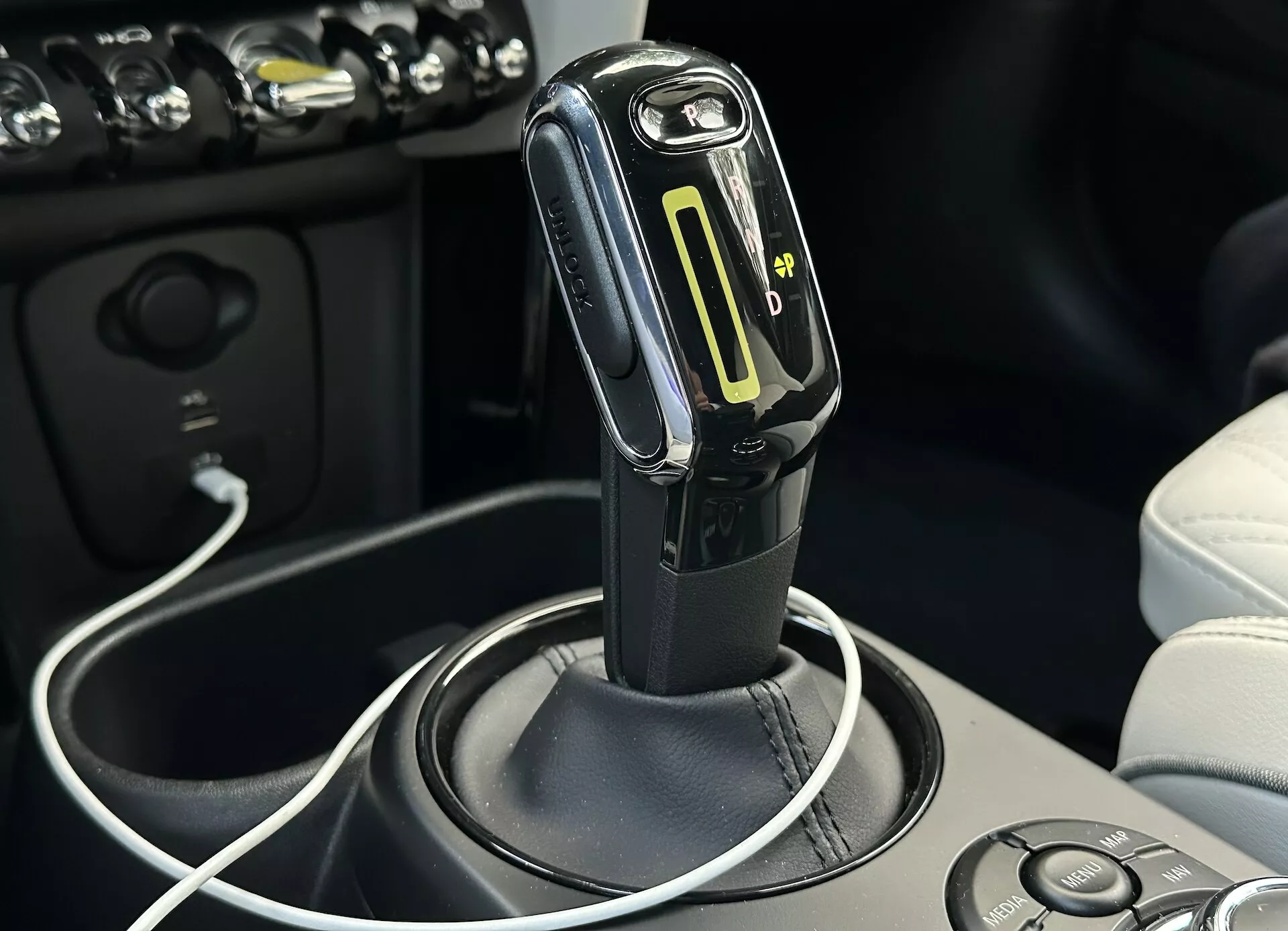 Gros plan sur le levier de vitesse à transmission automatique avec mode de changement manuel et indicateur à LED du rapport engagé dans l'intérieur du véhicule Mini Electric 2021