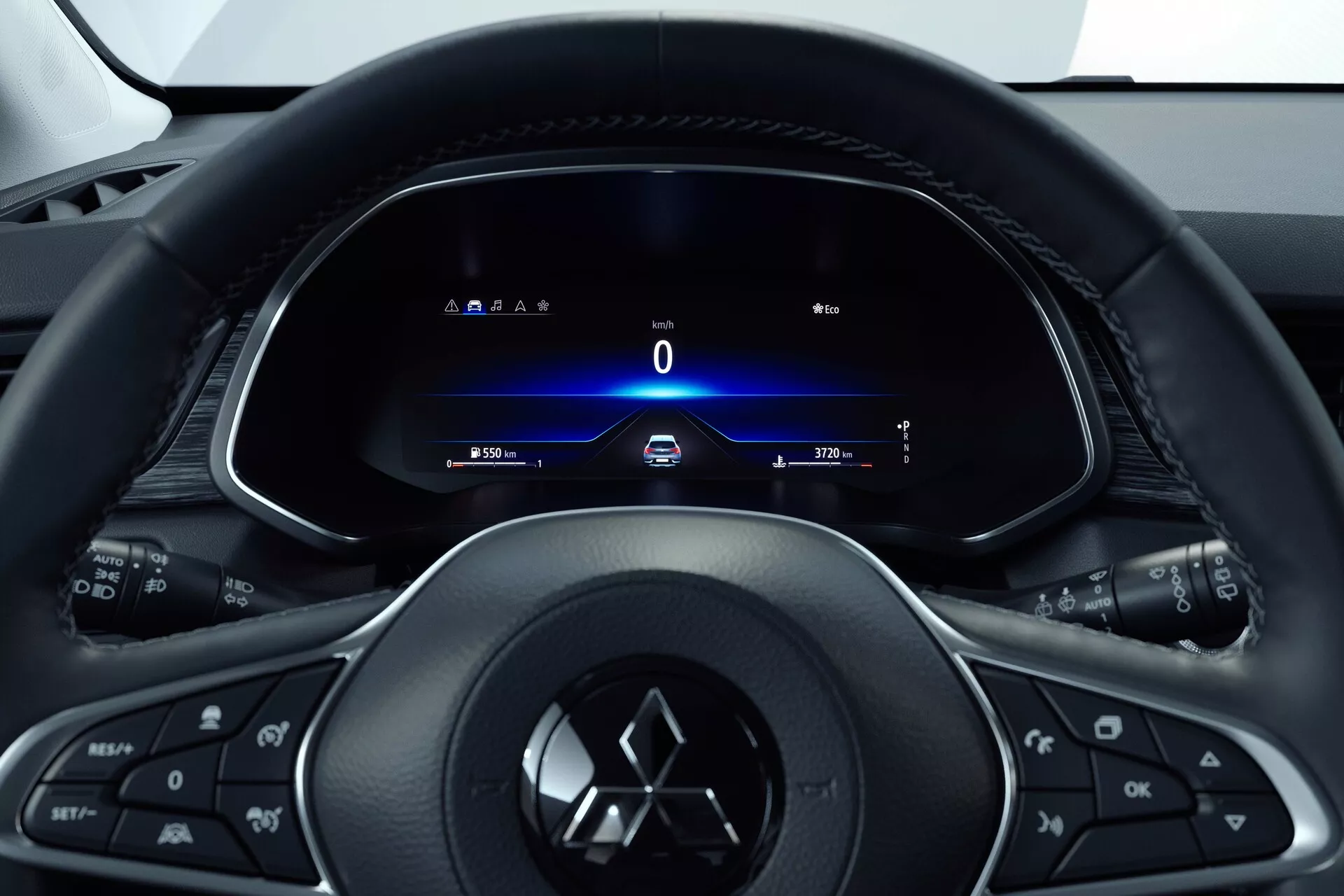 Vue intérieure de la Mitsubishi ASX 2023 (2e génération) depuis le siège du conducteur, focalisée sur le volant multifonction à trois branches avec des boutons pour les médias, le téléphone, le régulateur de vitesse et l'emblème du fabricant. Derrière, un tableau de bord entièrement numérique affiche un compteur de vitesse à 0 km/h, les indicateurs de direction, l'heure et l'odomètre. Le design type cockpit indique une conception centrée sur le conducteur avec une esthétique moderne et épurée mettant en avant la technologie et l'accès facile aux informations et commandes du véhicule.