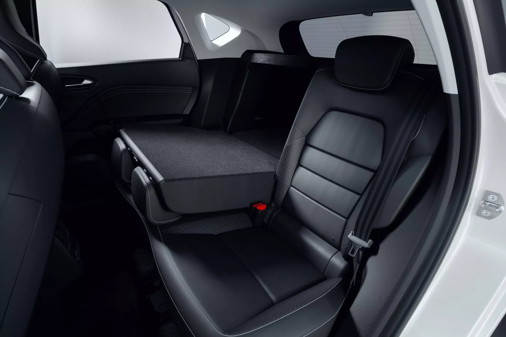 Vue intérieure de l'espace des sièges arrière de la Mitsubishi ASX 2023 (2ème génération), avec des sièges arrière en cuir noir avec appuie-têtes et surpiqûres détaillées. Le siège central partiellement rabattable révèle des porte-gobelets ou un espace de rangement, soulignant le design rabattable 60/40. Le bord de la porte passager est ouvert, montrant des éléments de design du panneau de porte de la voiture. L'image se concentre sur le confort, la qualité des matériaux et les fonctions de commodité, respectant les normes de sécurité modernes, y compris les ceintures de sécurité à trois points.