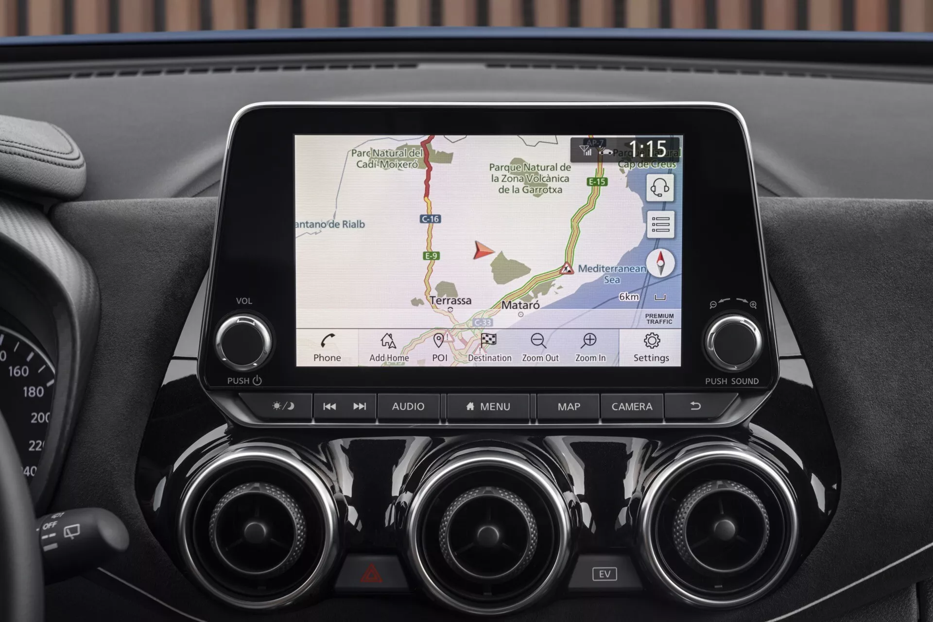 Gros plan sur l'écran d'infodivertissement et le tableau de bord central du Nissan Juke F16 2019 montrant la navigation GPS, la connectivité téléphonique, les bouches d'air et les boutons de contrôle pour la technologie avancée et le confort
