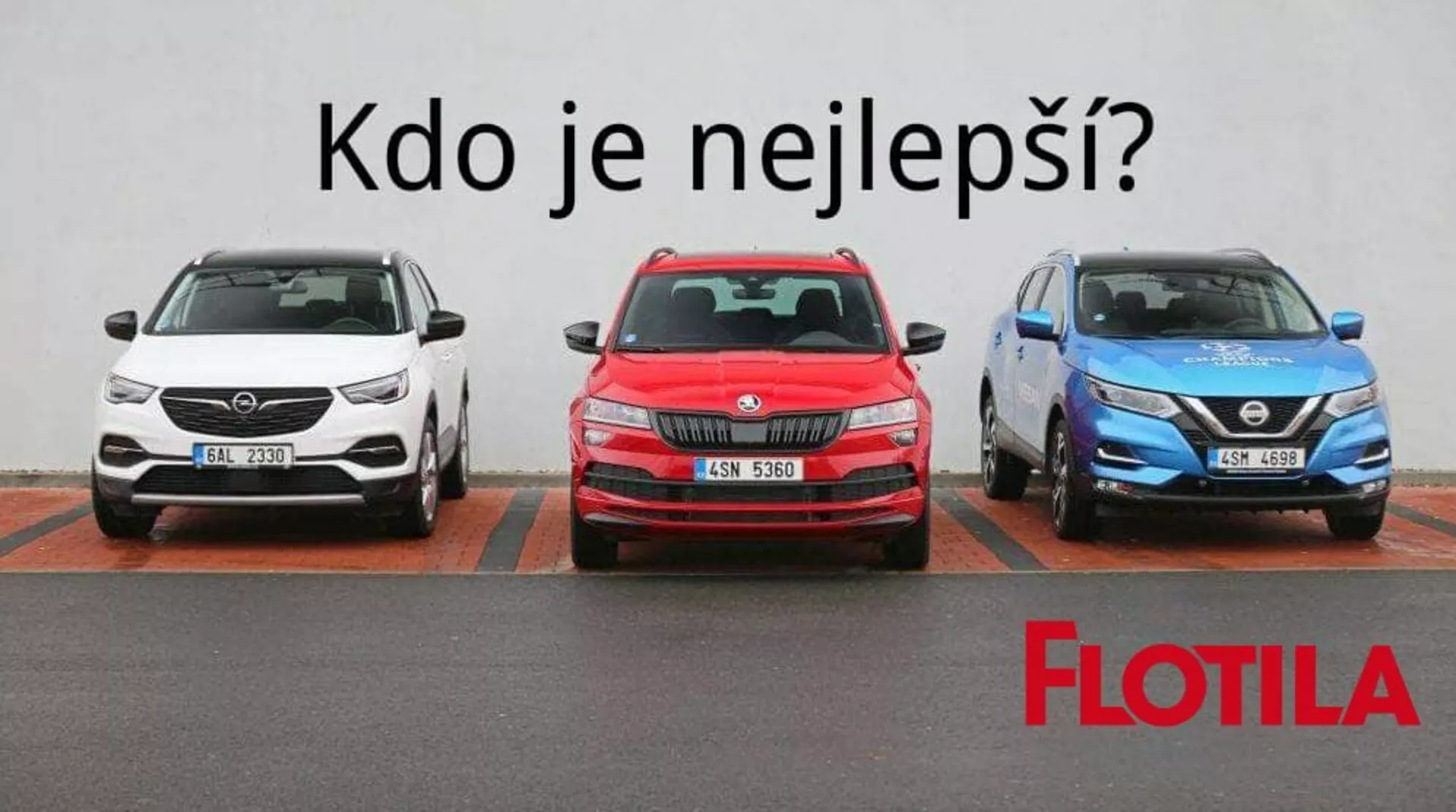 Une alignée de trois voitures sur un parking, incluant un SUV blanc avec des feux de jour LED modernes et des jantes en alliage à multiples rayons, une hatchback rouge avec un pare-chocs avant sportif et des jantes en alliage, et un crossover bleu avec une grille en V et des phares LED angulaires, le tout face à la caméra contre un mur uni avec marquage des places de parking.